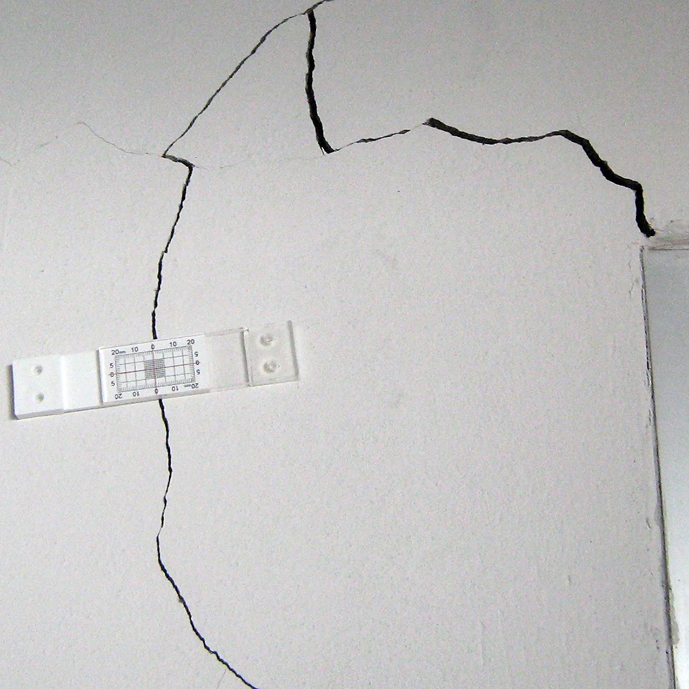 Figure 4. TAMCO engineer installed Buildera CRACKMON ® 2D Crack Monitor over shear-wall crack adjacent to door frame
