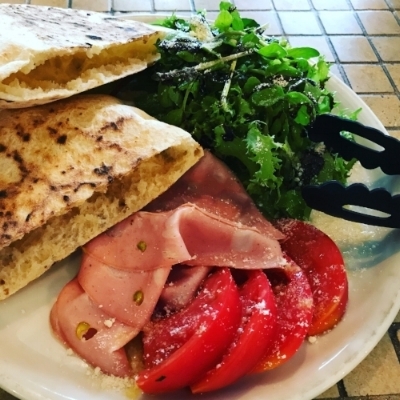 Ciabatta with peppered ham, tomato and leaves