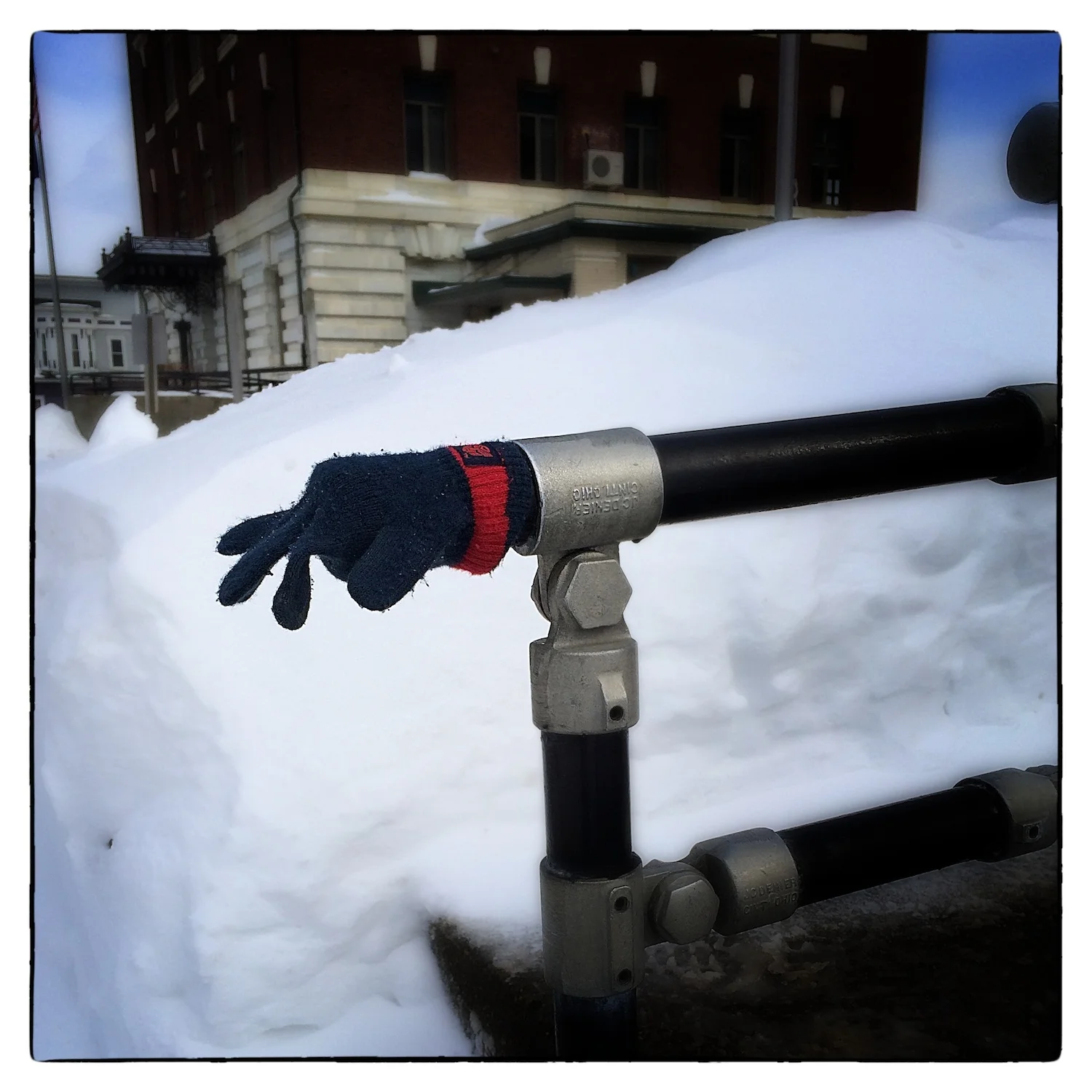 A glove warms the hand rail at the Orleans County Superior Courthouse in Newport, Vt., shot February 18, 2014. The U.S. Courthouse is in the background.