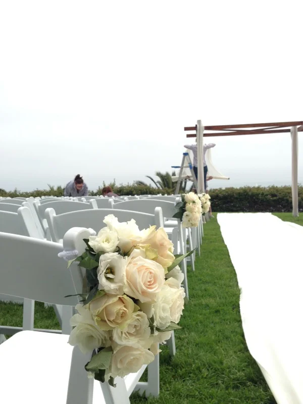 Creating the ceremony site. The Chuppah was draped in yards of chiffon. Fabric was laid down to create the aisle runner.