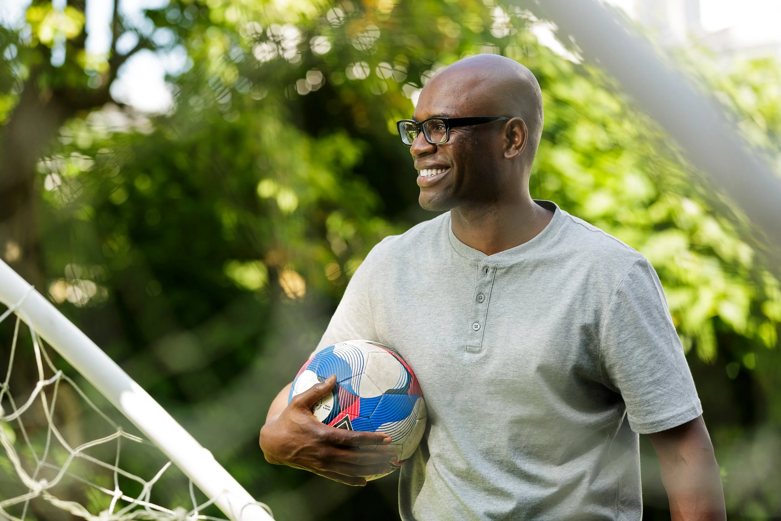 A father holds a football in his garden