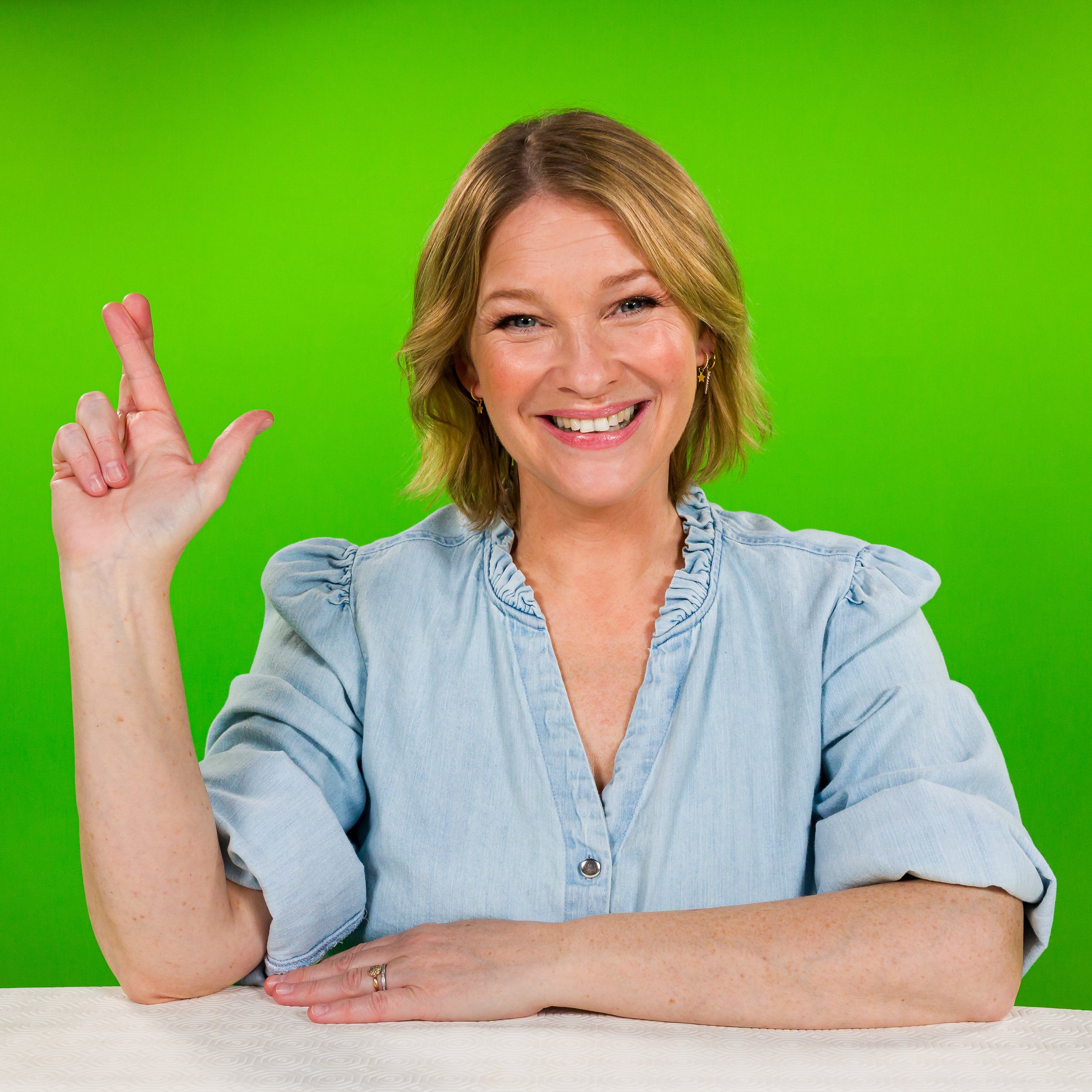 Actress Joanna Page in front of a green background for The National Lottery