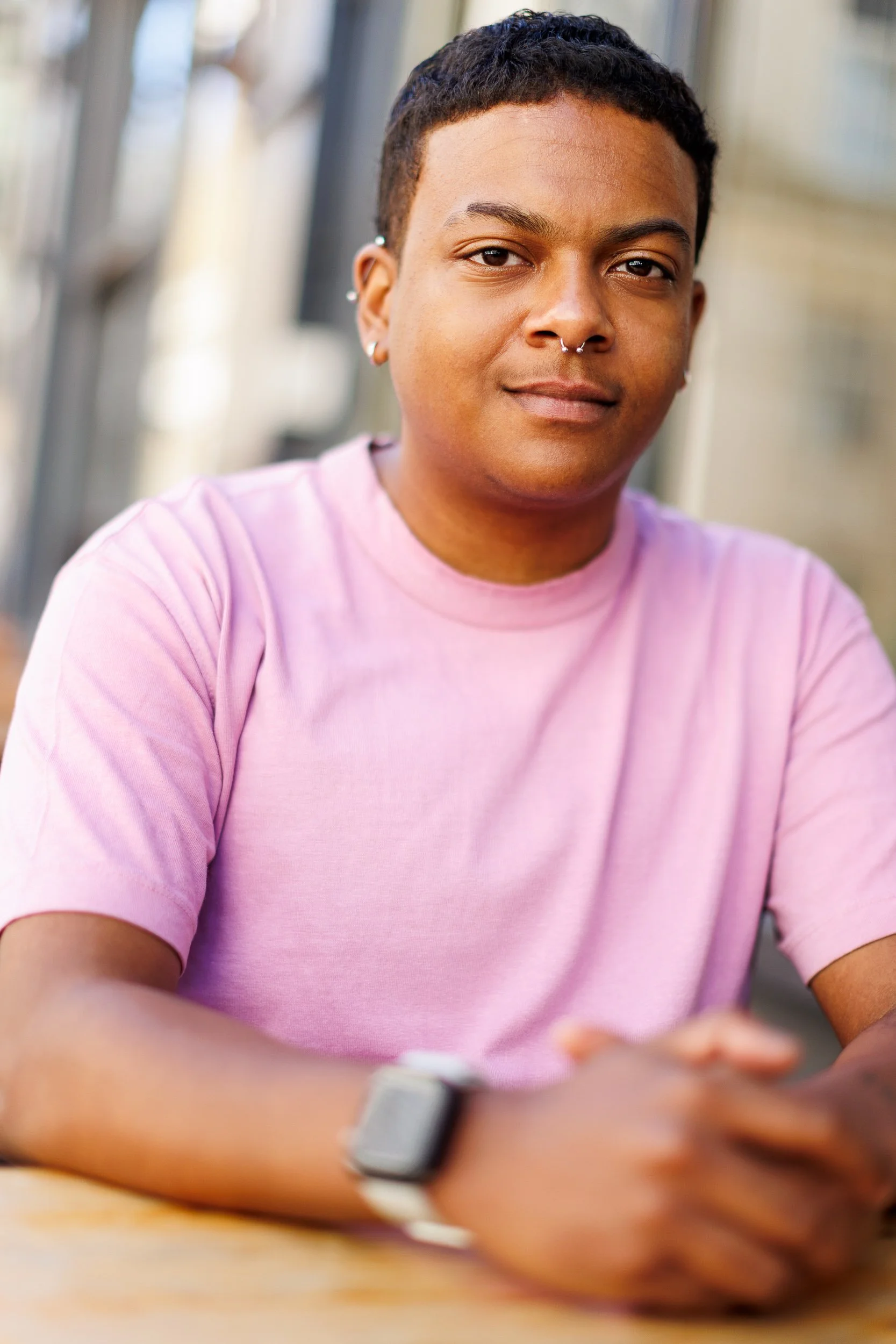 Shallow depth of field portrait of a young man in a pink shirt 