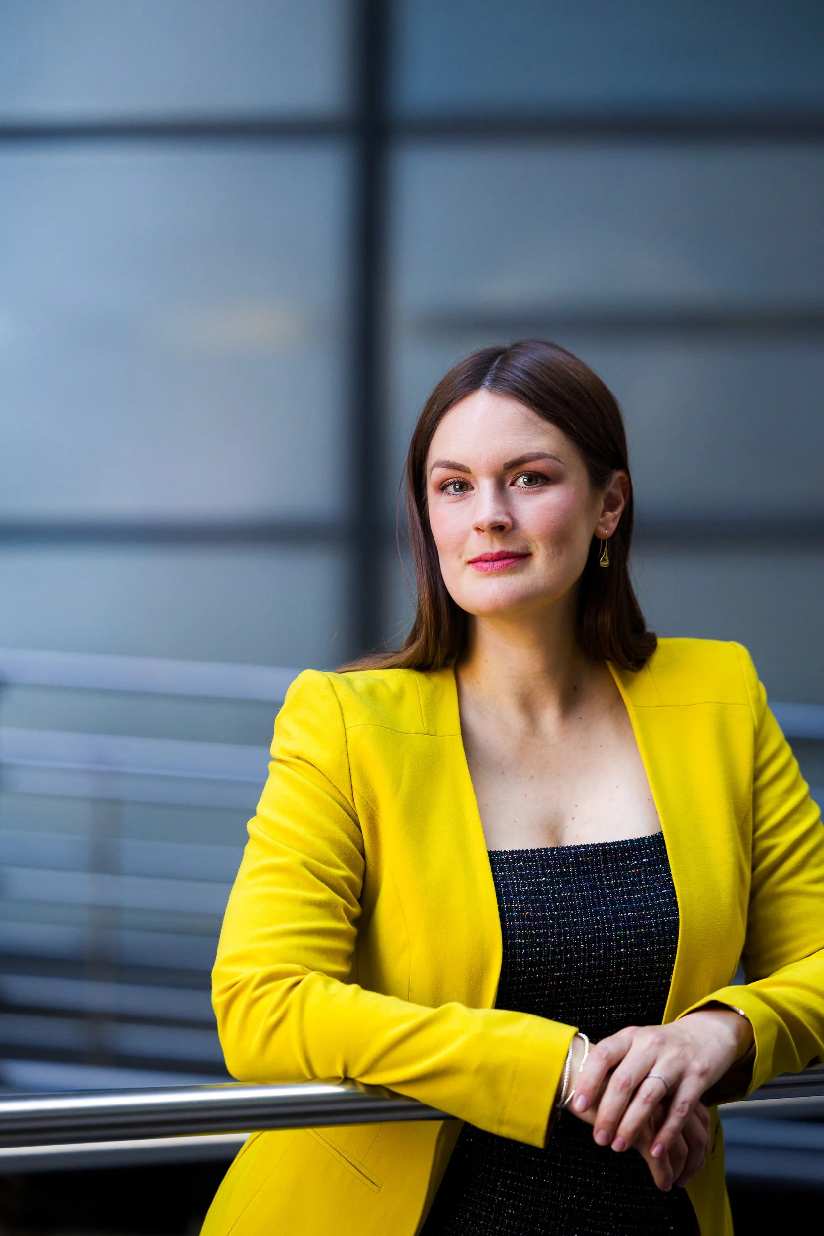A businesswoman leans on a railing in London
