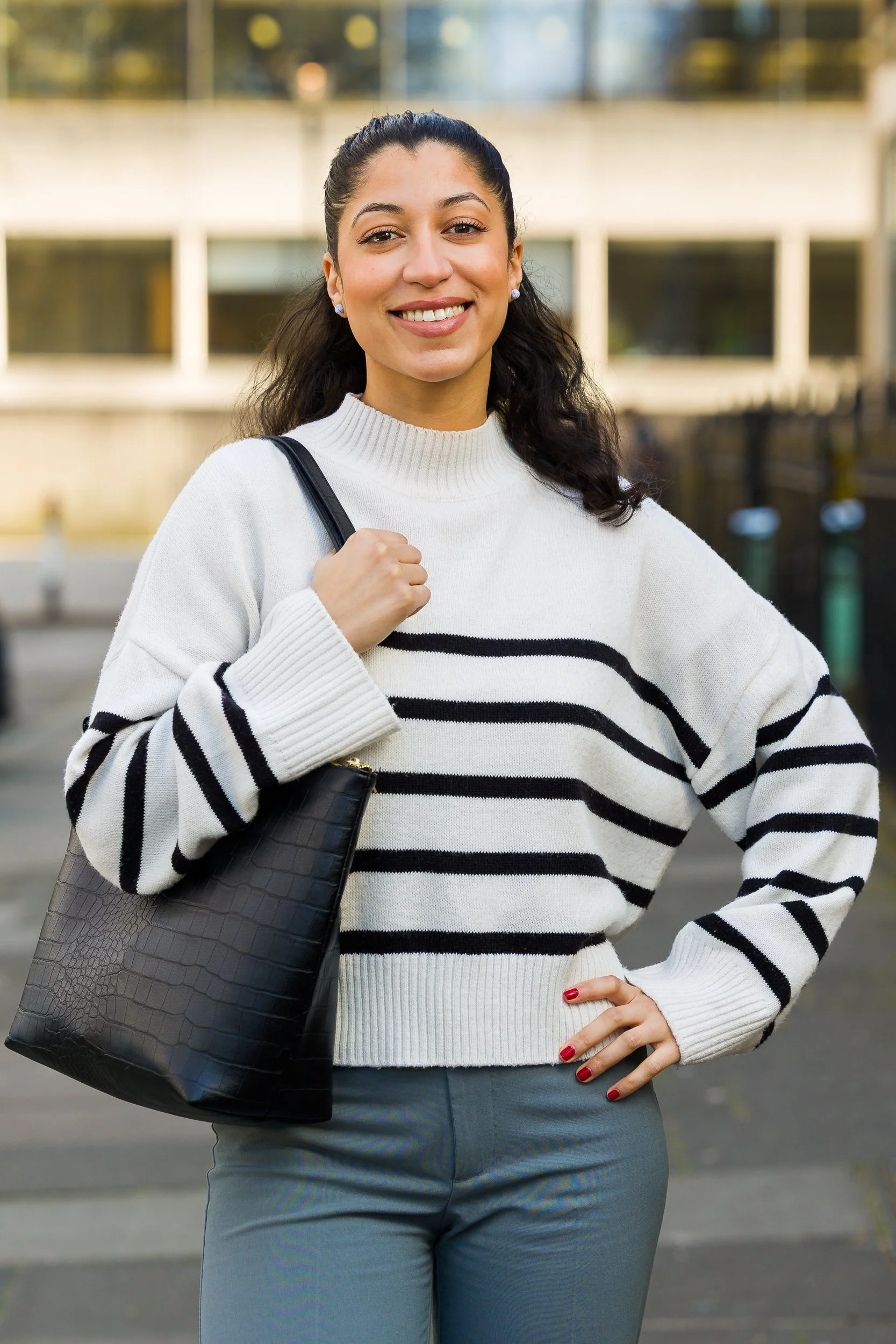 A female student poses outside her university building 