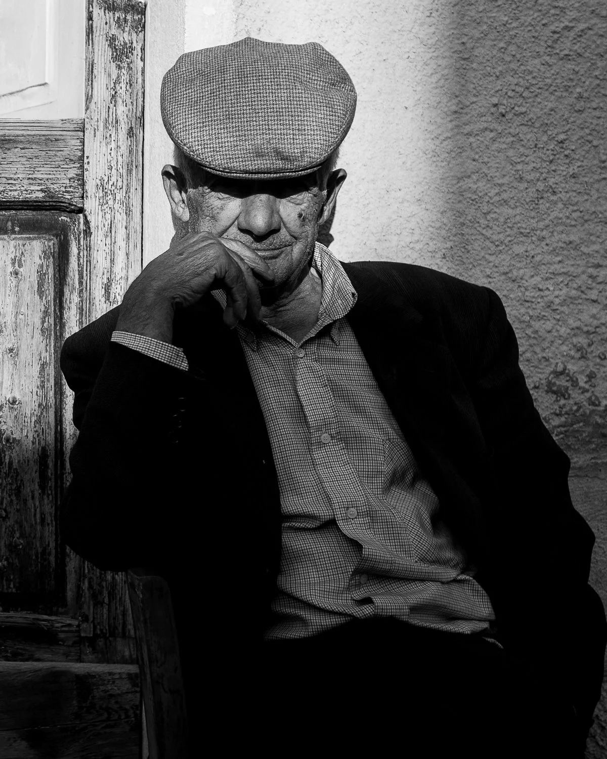 Black and white image of an old man in the afternoon sun