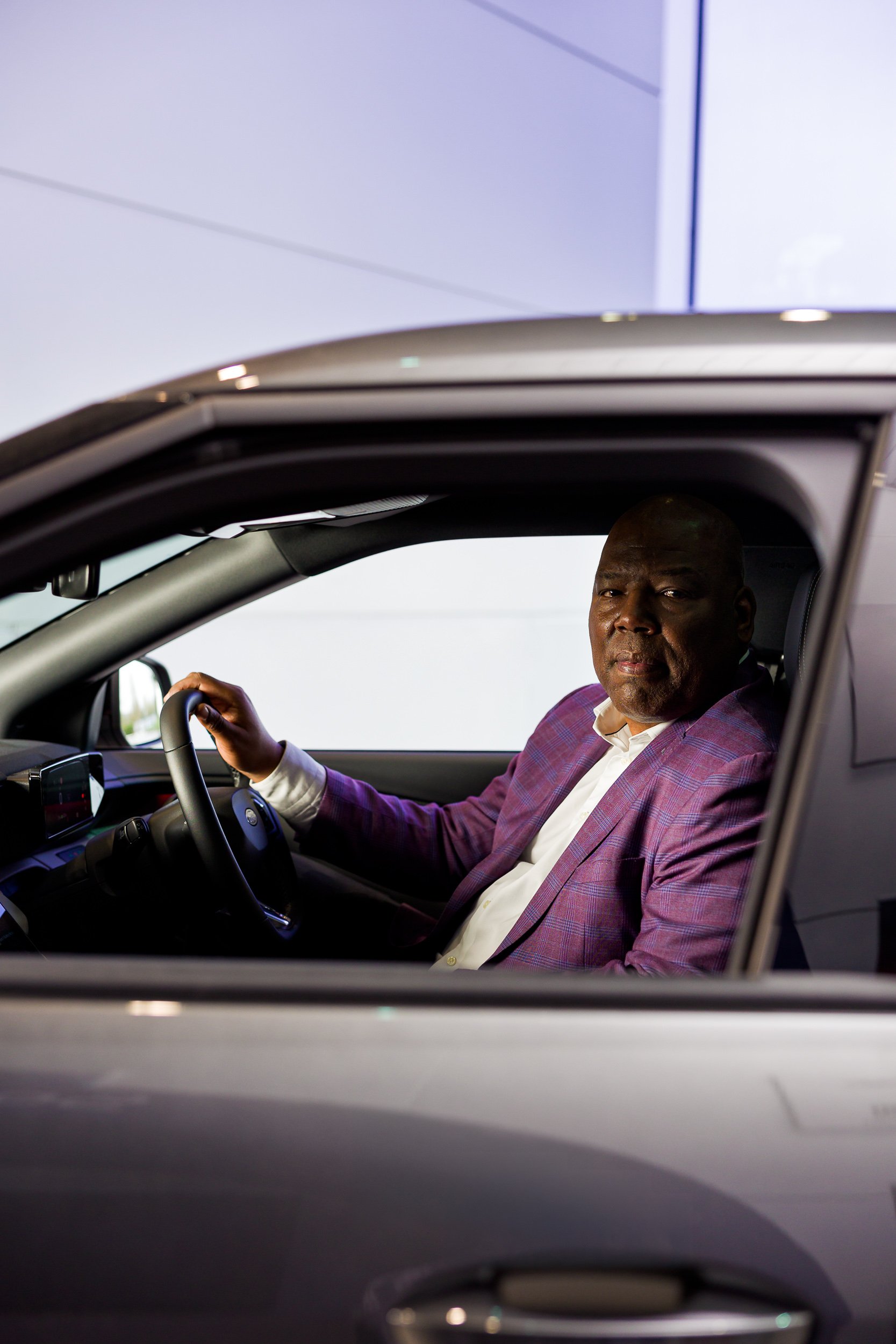 A man sitting in a car looking at the camera
