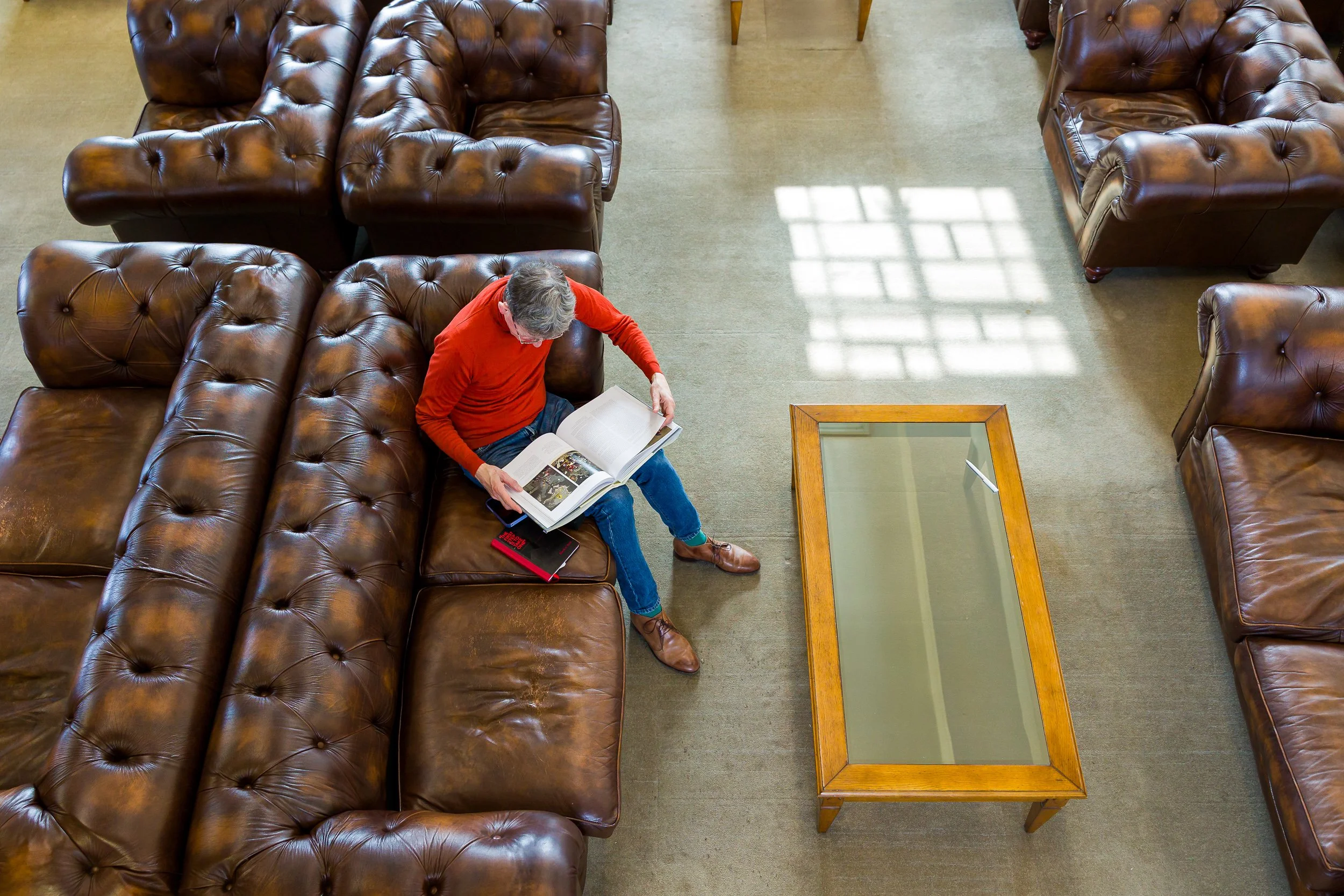 A mature student reads on sofas in a libary
