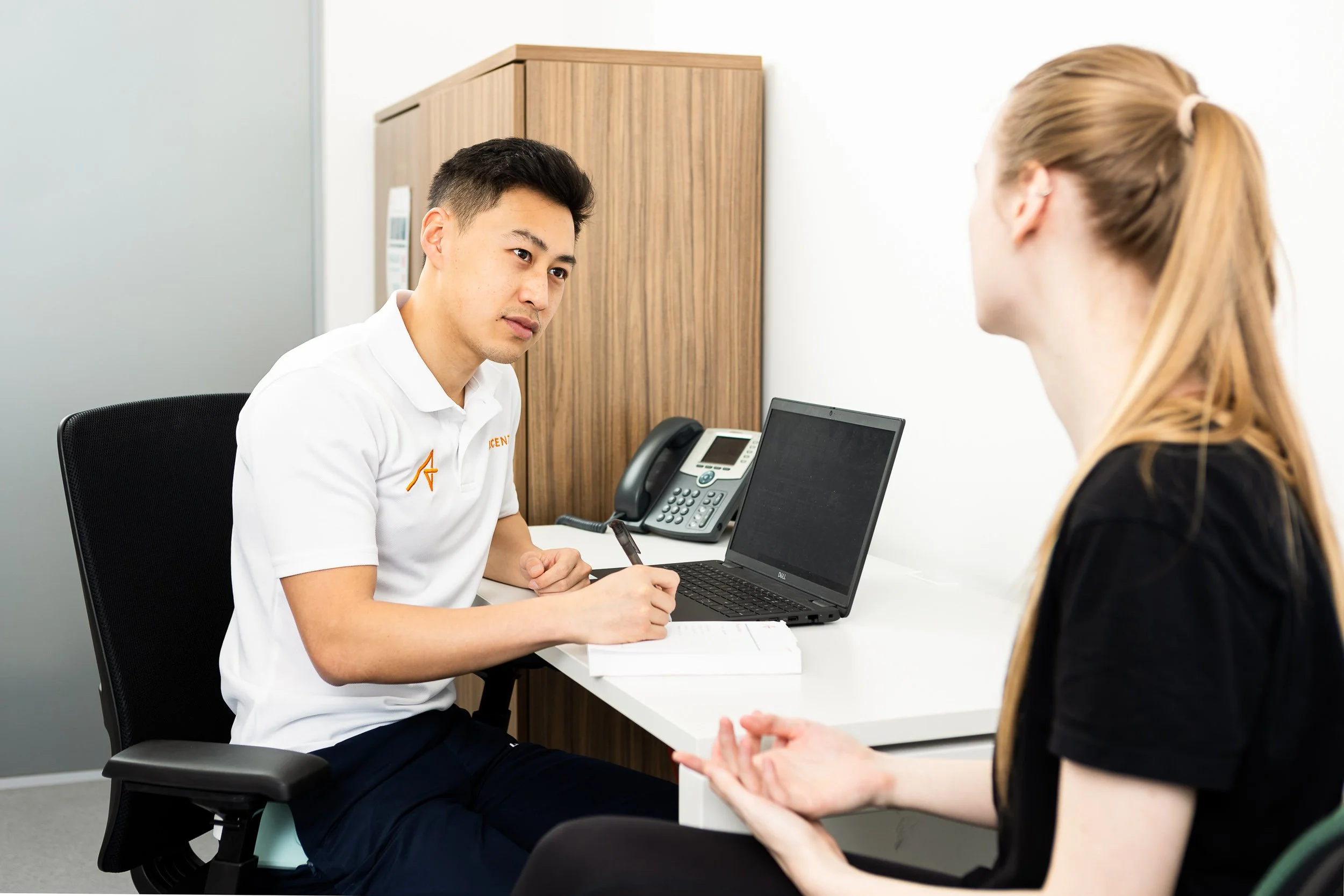 A healthcare professional listens to a patient in his office