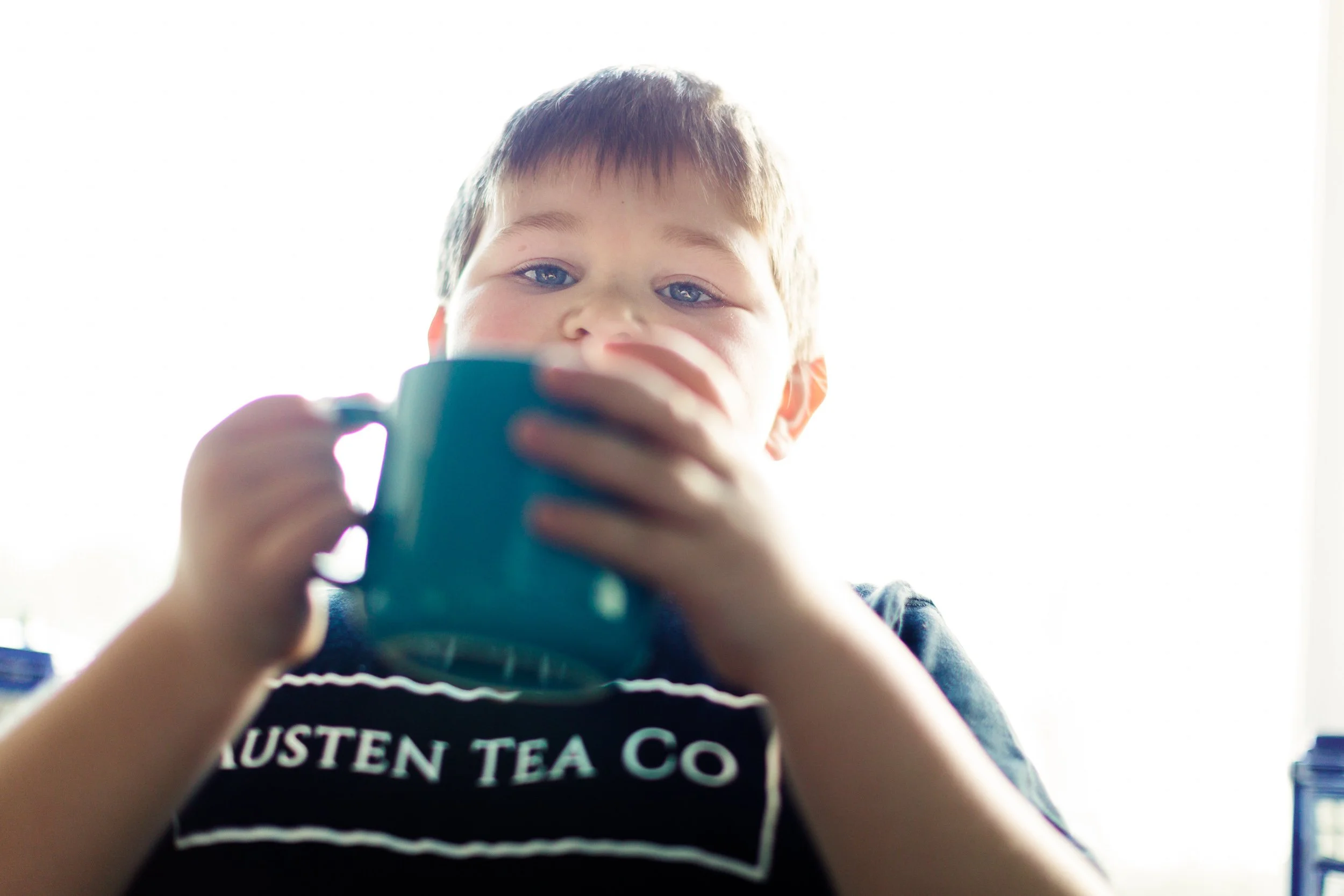 A boy holds a cup of tea
