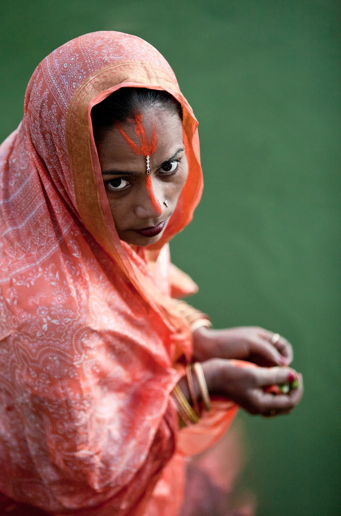 A young woman prays at a religious ceremony in a lake