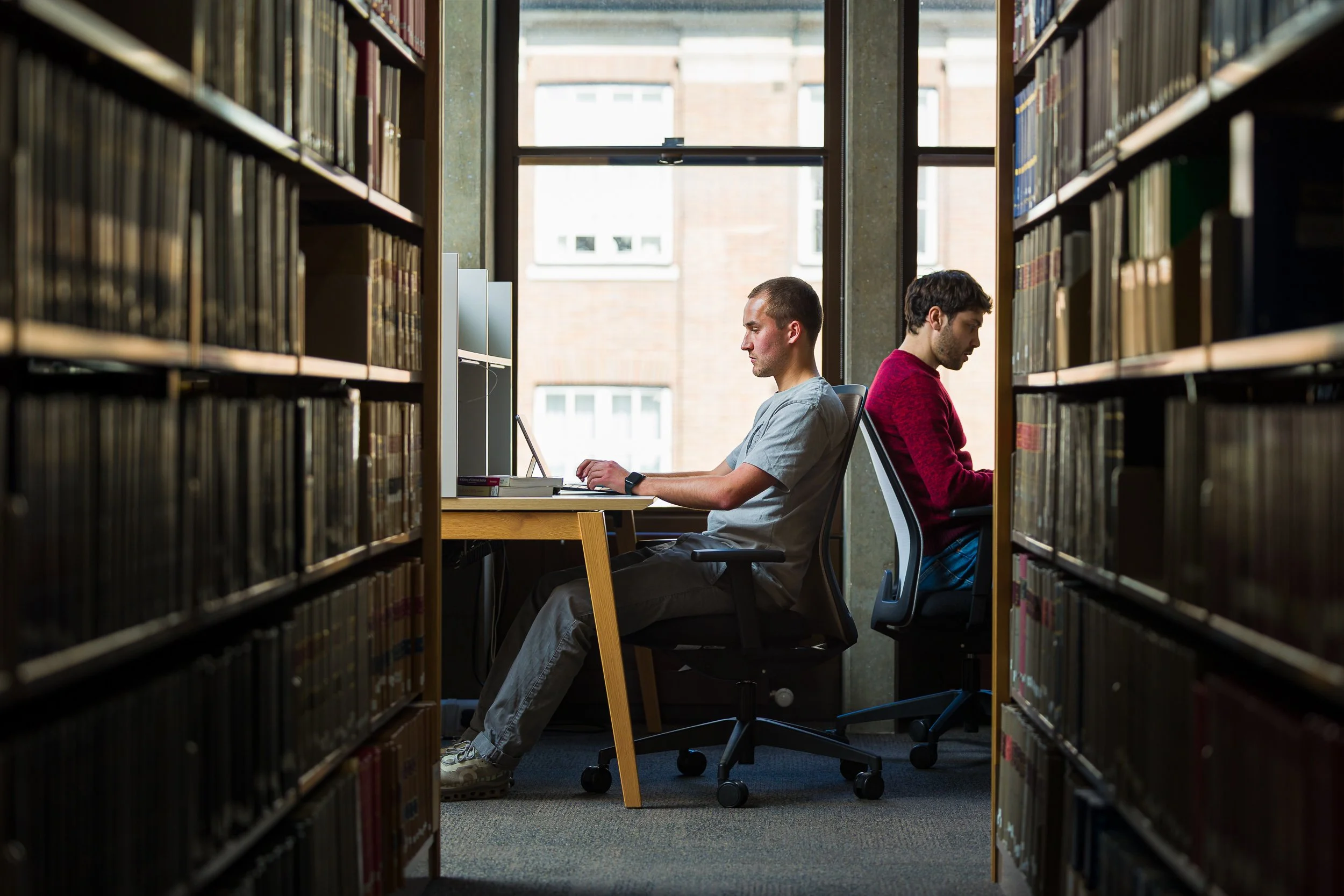 A student works on his laptop in a university library