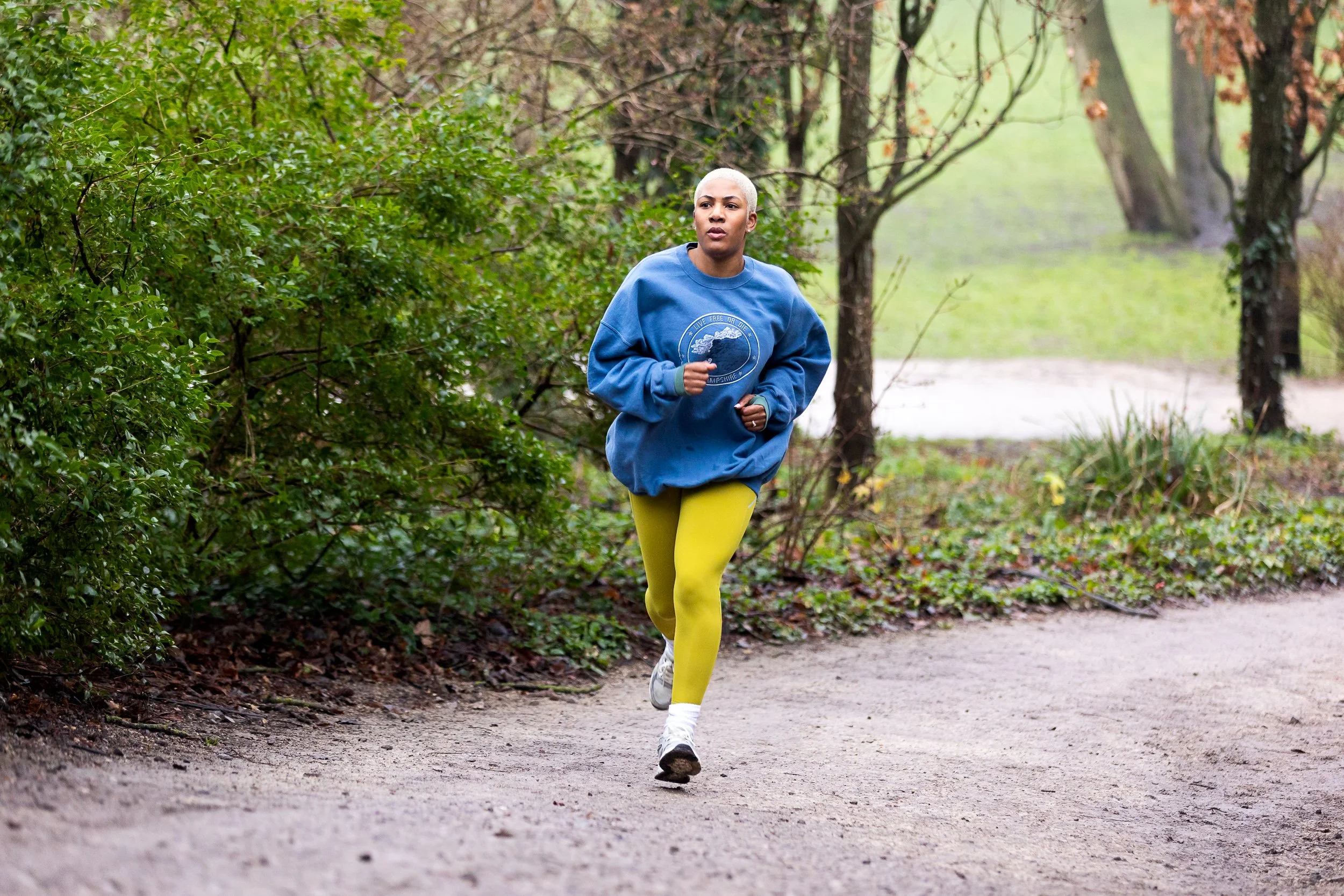 A young woman runs through a park