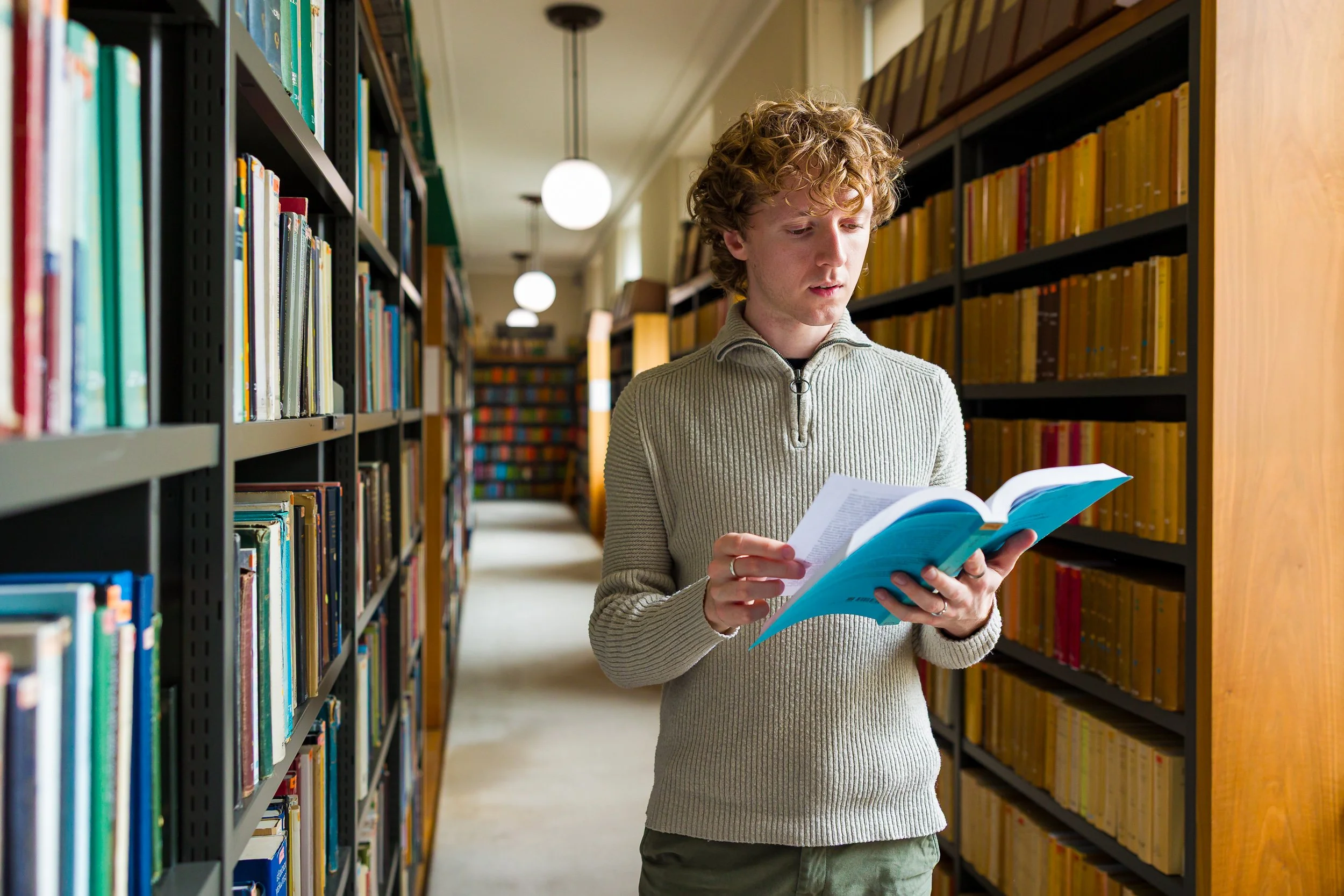 A student browses a book in a library
