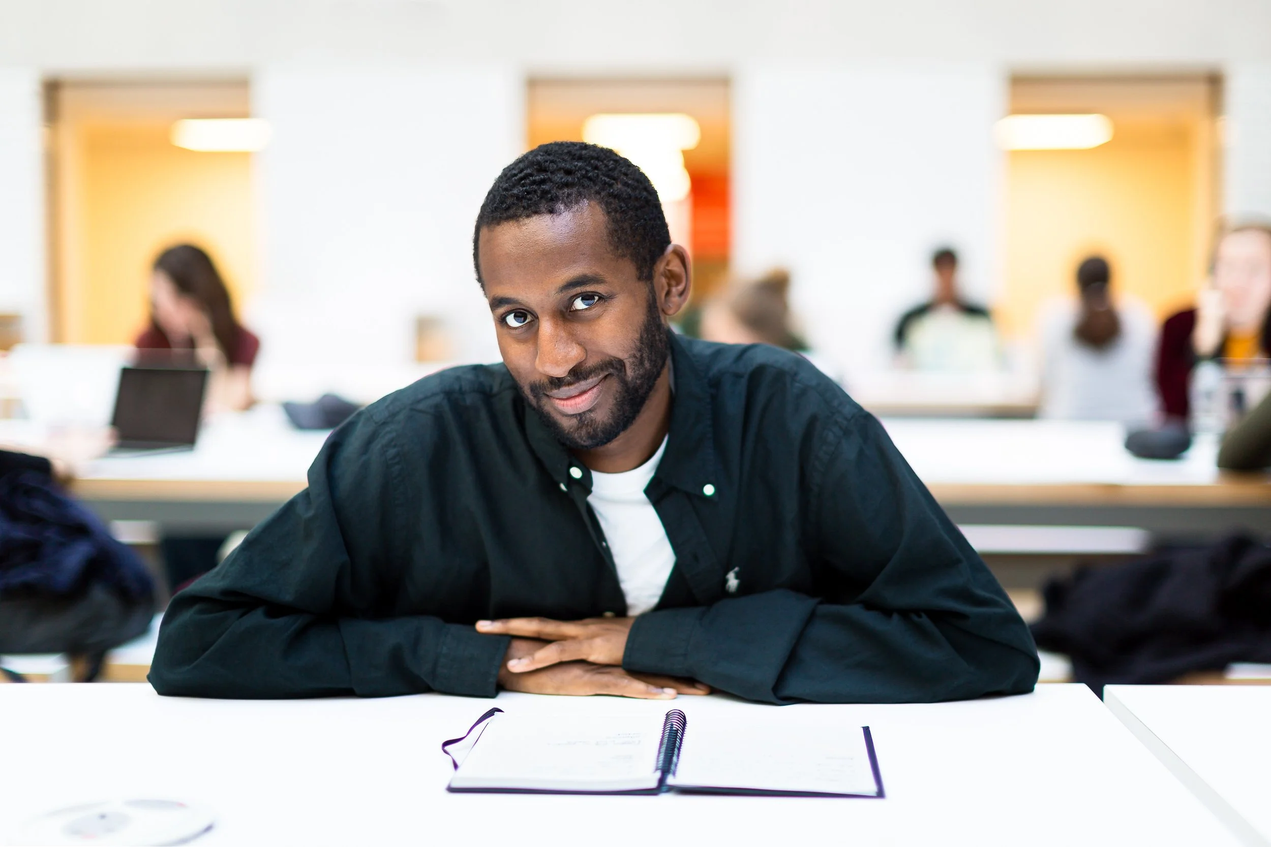 A university student looks up from his books in a library