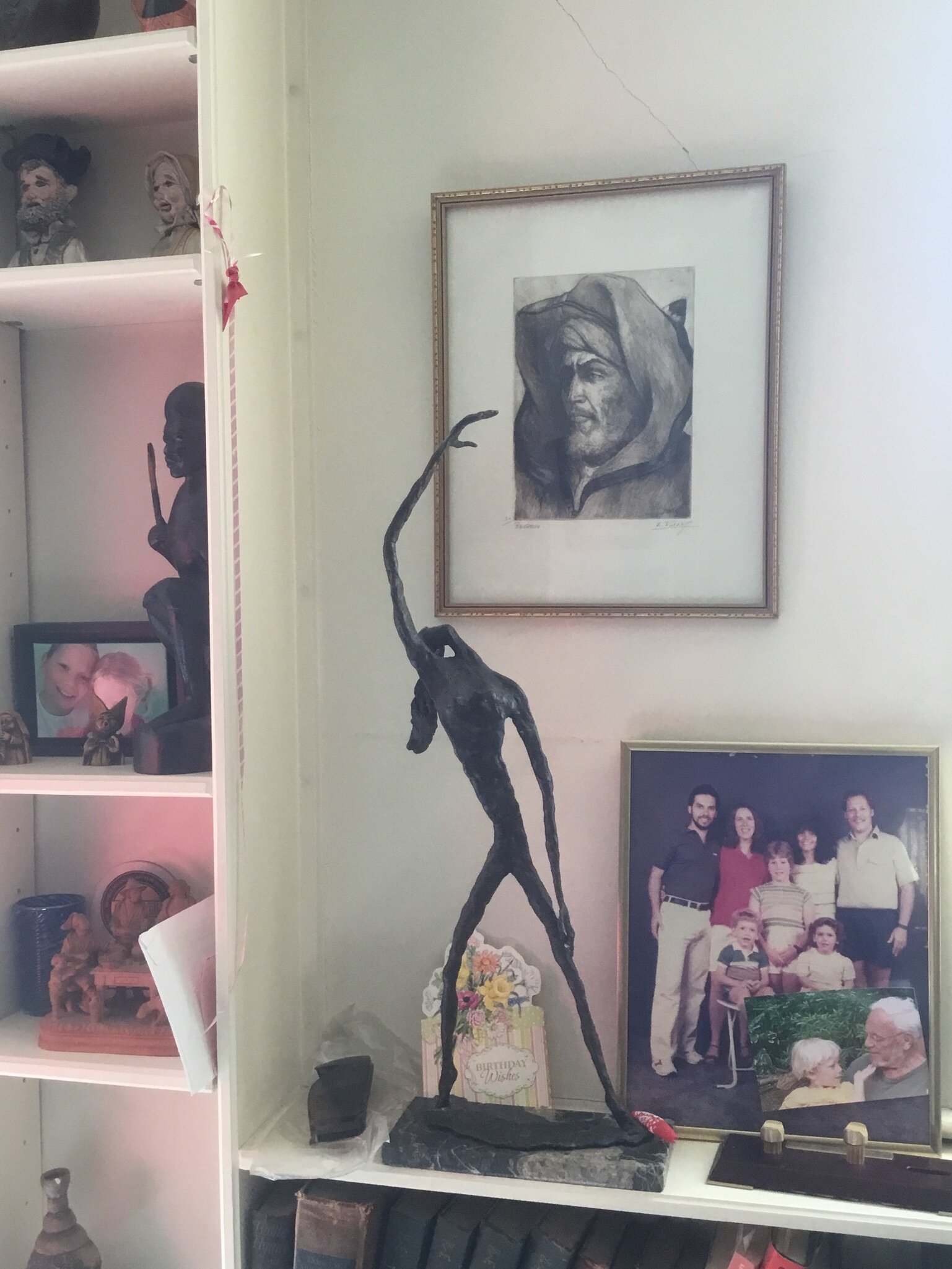 Several sculptures, bearded hooded print and family photos