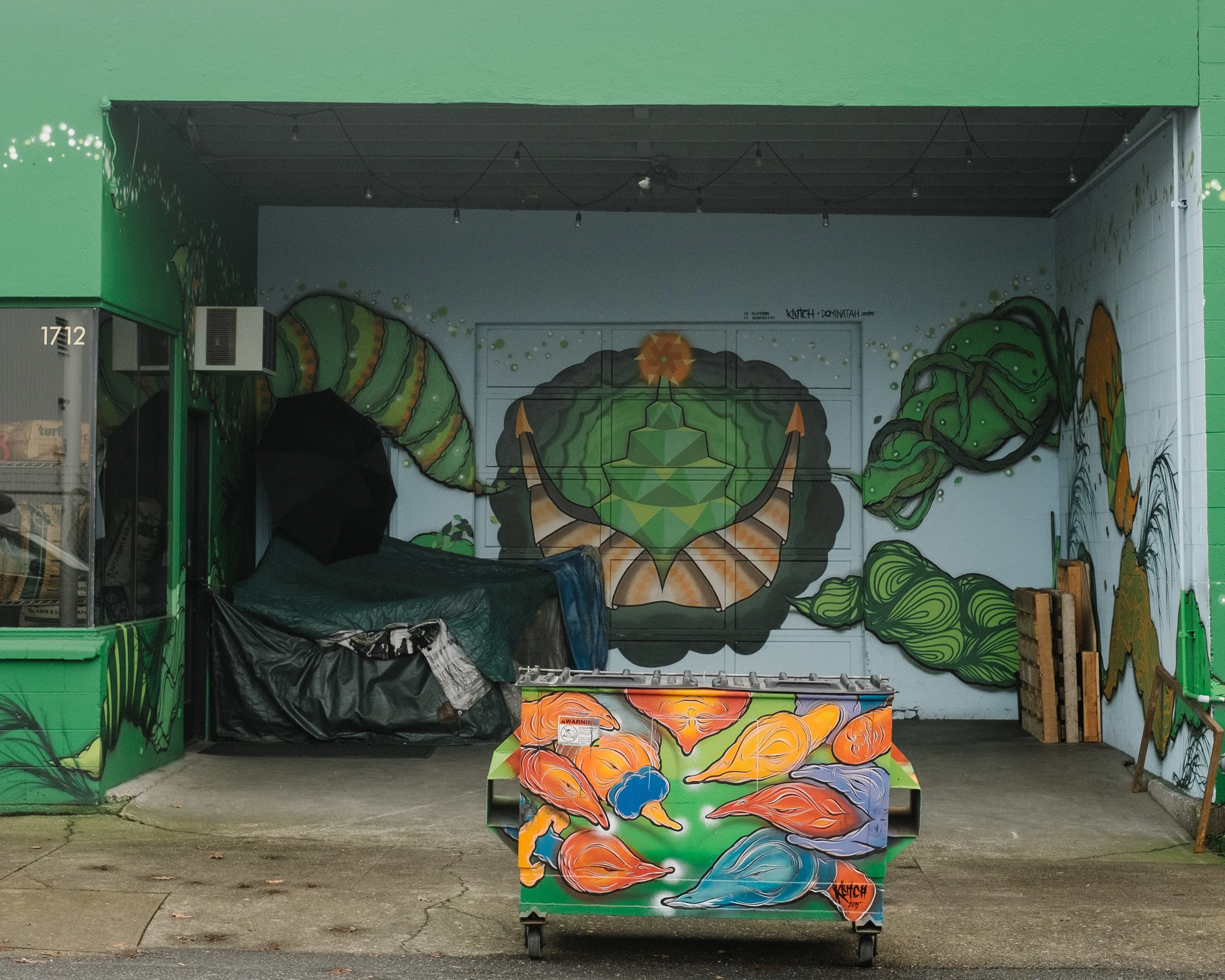 Photograph of a homeless camp near a storefront mural in Portland, Oregon by Philadelphia based photographer Thomas Lawn