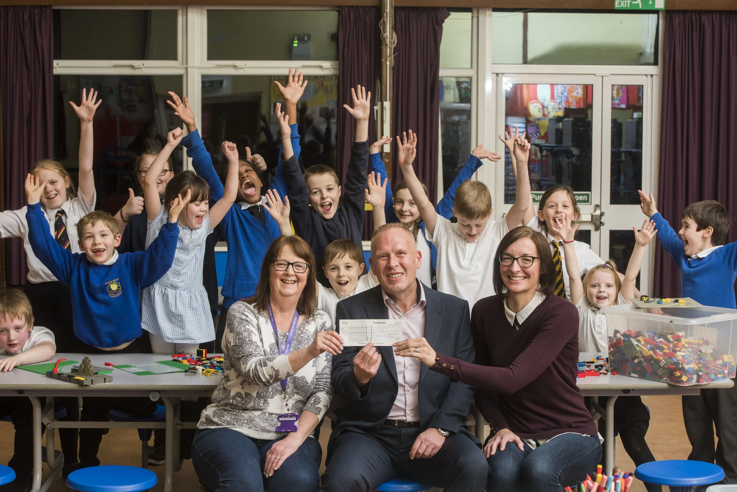 Pictured: Sam Collings from Computershare presents a cheque for £1,000 to help Camdean Primary School purchase after school club equipment. The money was won for the club by mum Tracy McDonald (right) and the cheque was presented to Diane Malcolm Acting Senior (left).