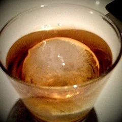 I have been looking for somewhere to drink my whisky with a nice spherical ice cube. It has nothing to do with the aesthetic and everything to do with physics. A spherical ice "cube" has a much improved surface to volume ratio - this reduces the thermal transfer to the ice and makes it last longer. In essence it allows you to sip your whisky at your leisure without getting it all wet and tasteless.
If you are very lucky you can get your whisky or fine bourbon with a spherical ice cube at 50 plates .