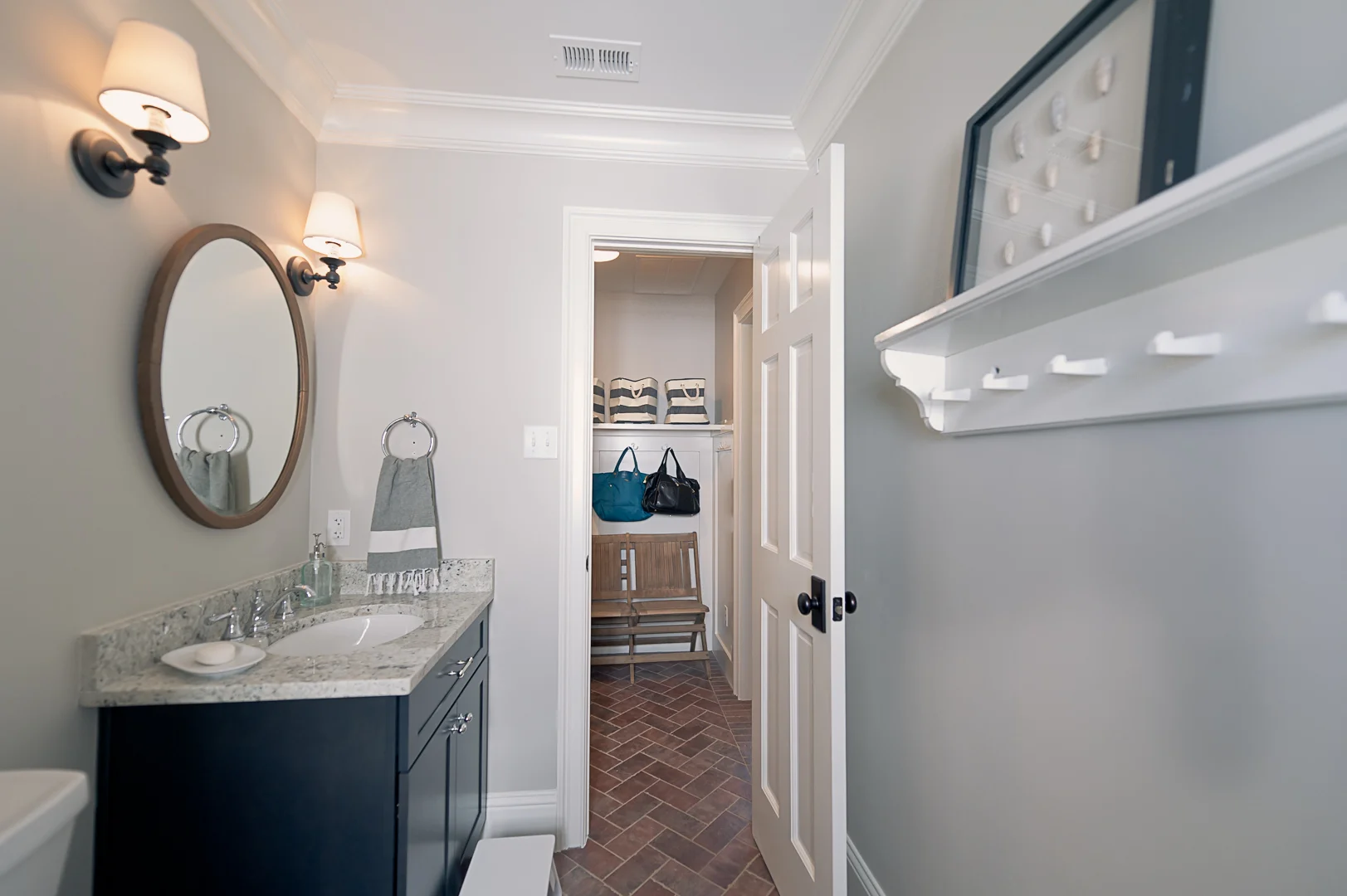 After: From the exterior door, looking back.&nbsp; The biggest change in this space to was to swap the solid exterior door for one with windows, letting light into a very dark room.&nbsp; We also put in brick-like tile, and new cabinetry, counters, …