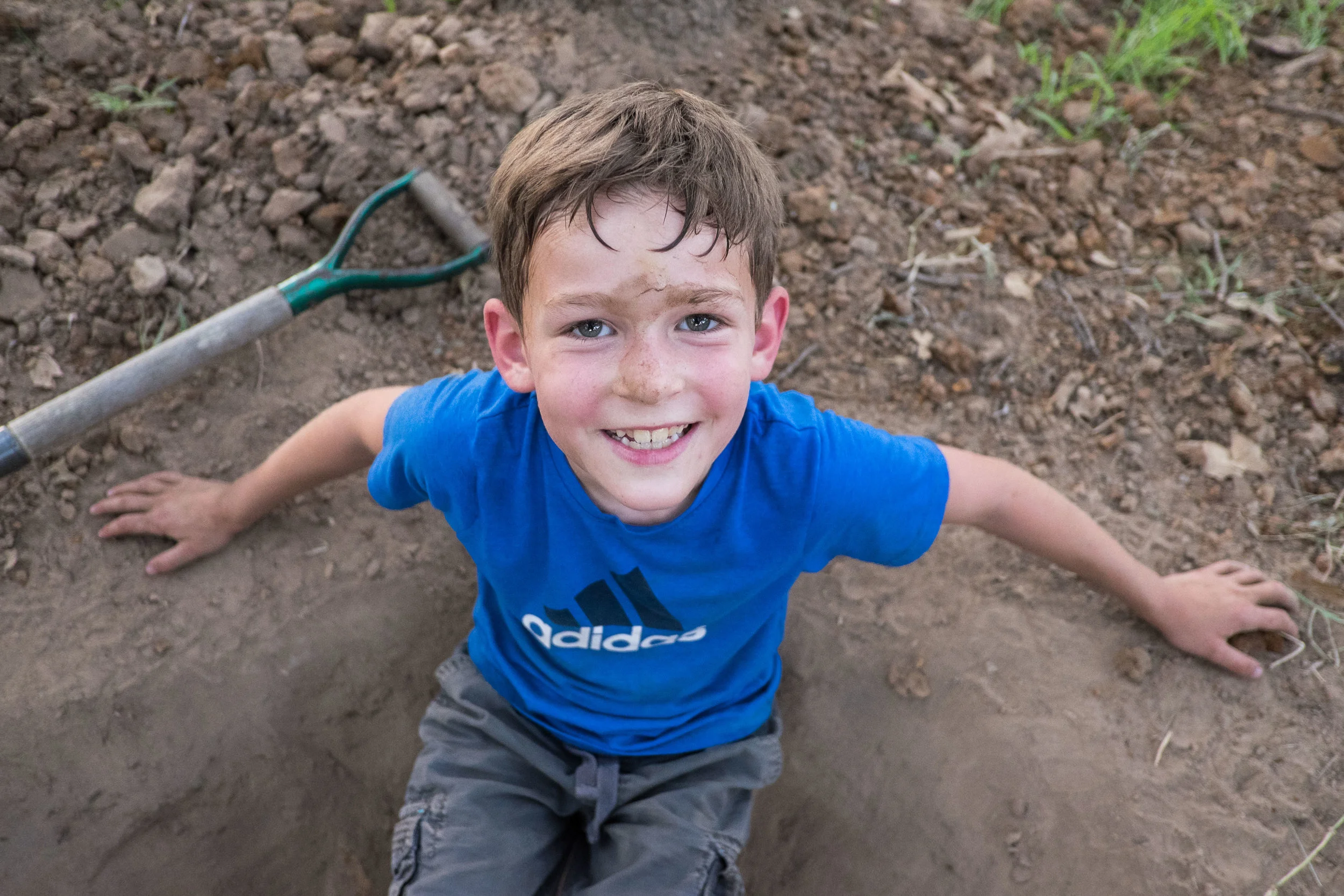 This kid is "building an underground house" in our side yard. 