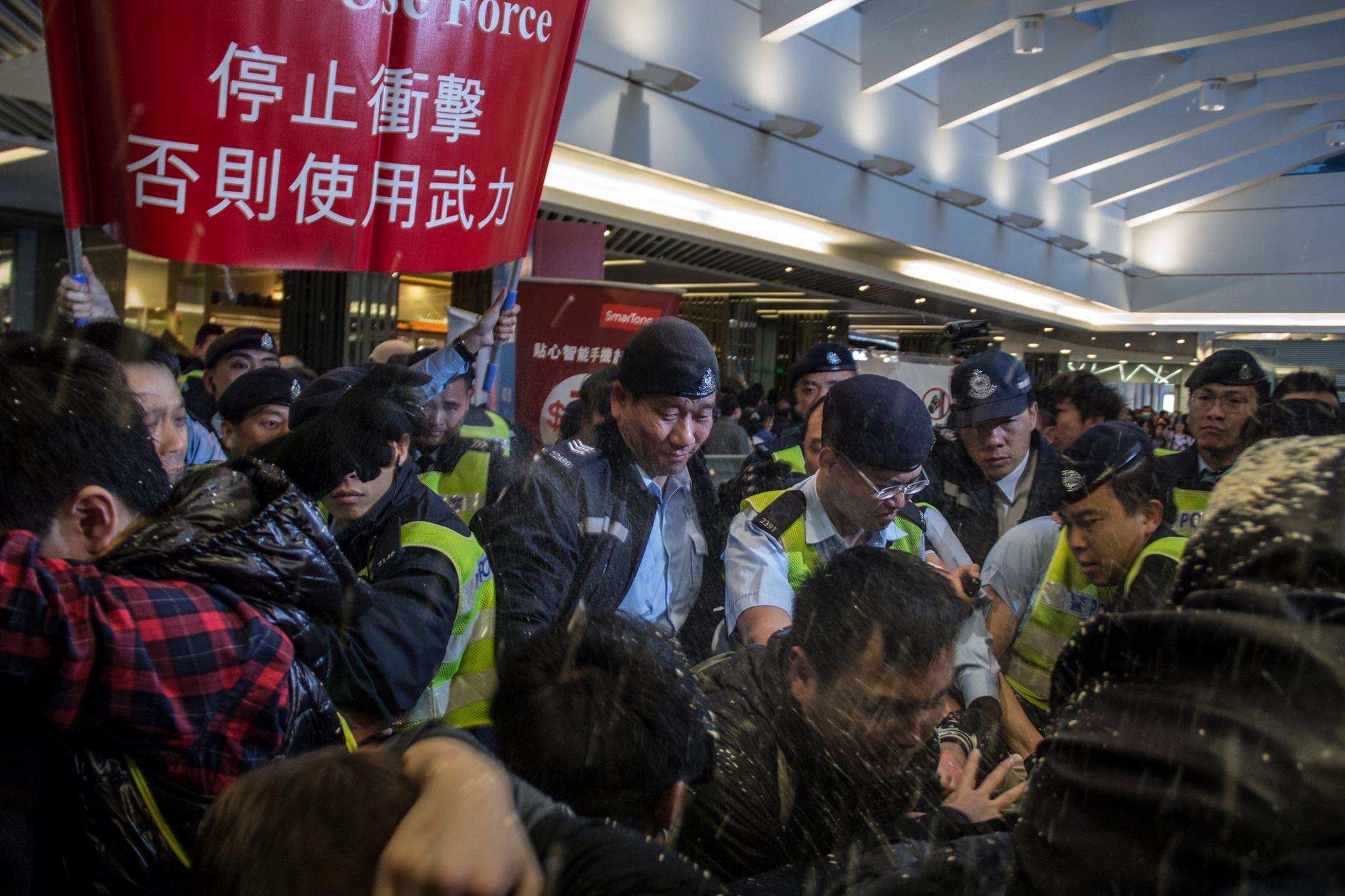 Pepper spraying protesters fighting against parallel traders overwhelming Hong Kong.