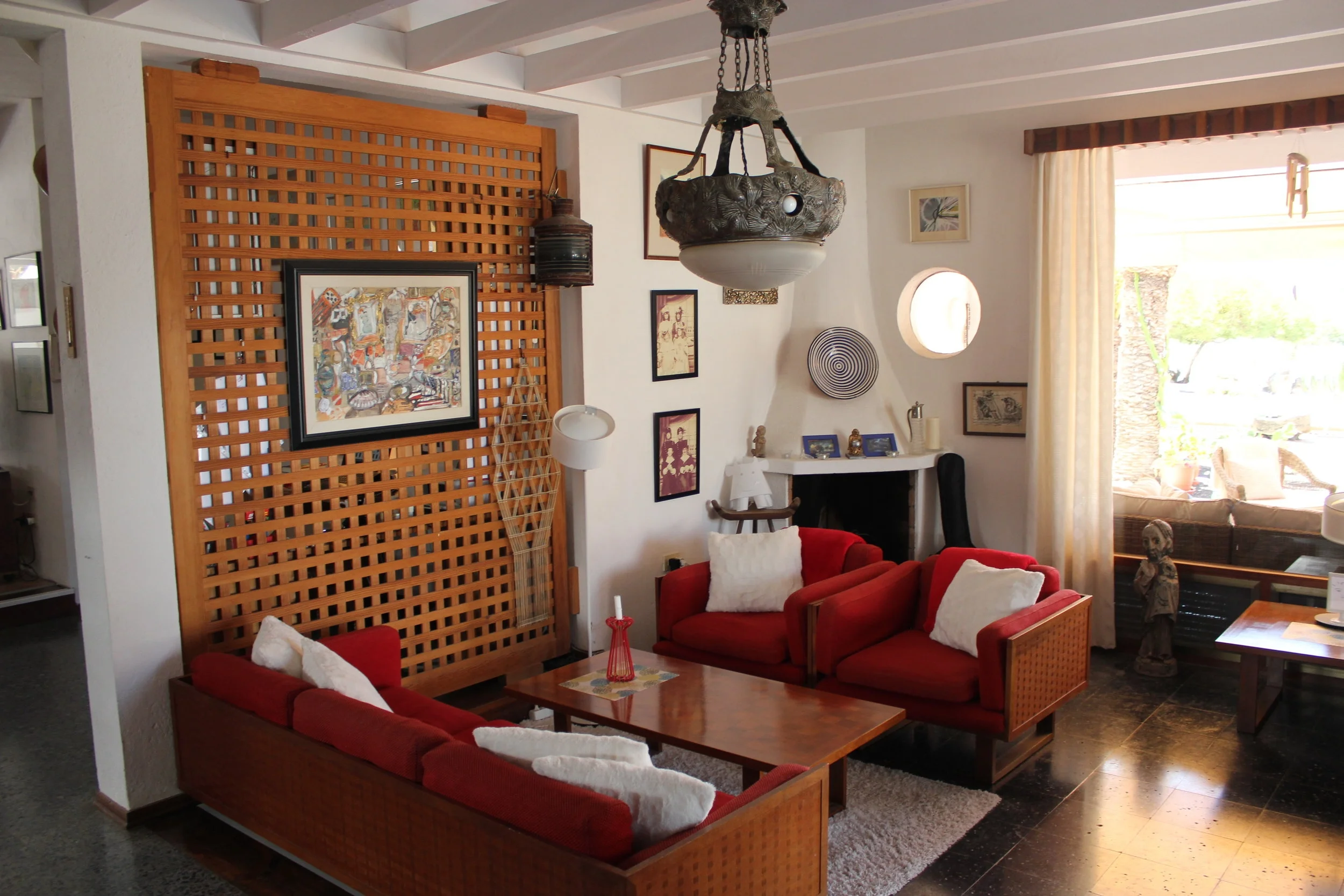 Sofakrok i stuen med peis -  utsikt  mot hovedterrasse, basseng og hagehage