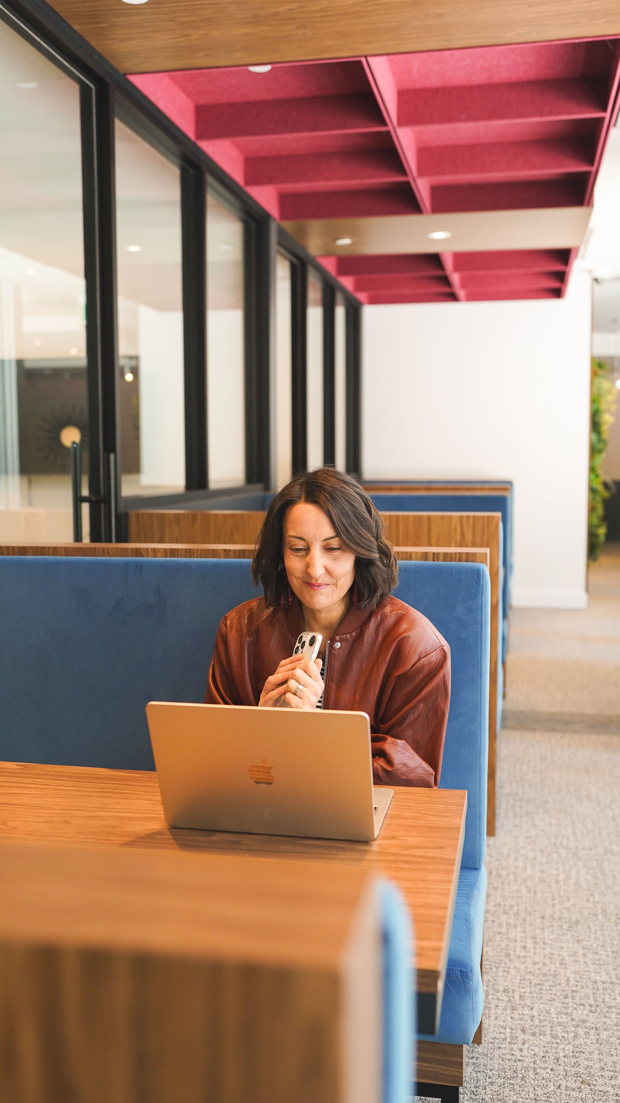 Jaime au travail sur son ordinateur portable dans une banquette de bureau
