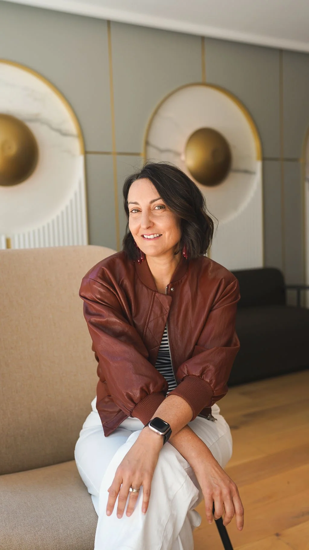 Jaime assise sur une chaise beige, souriante