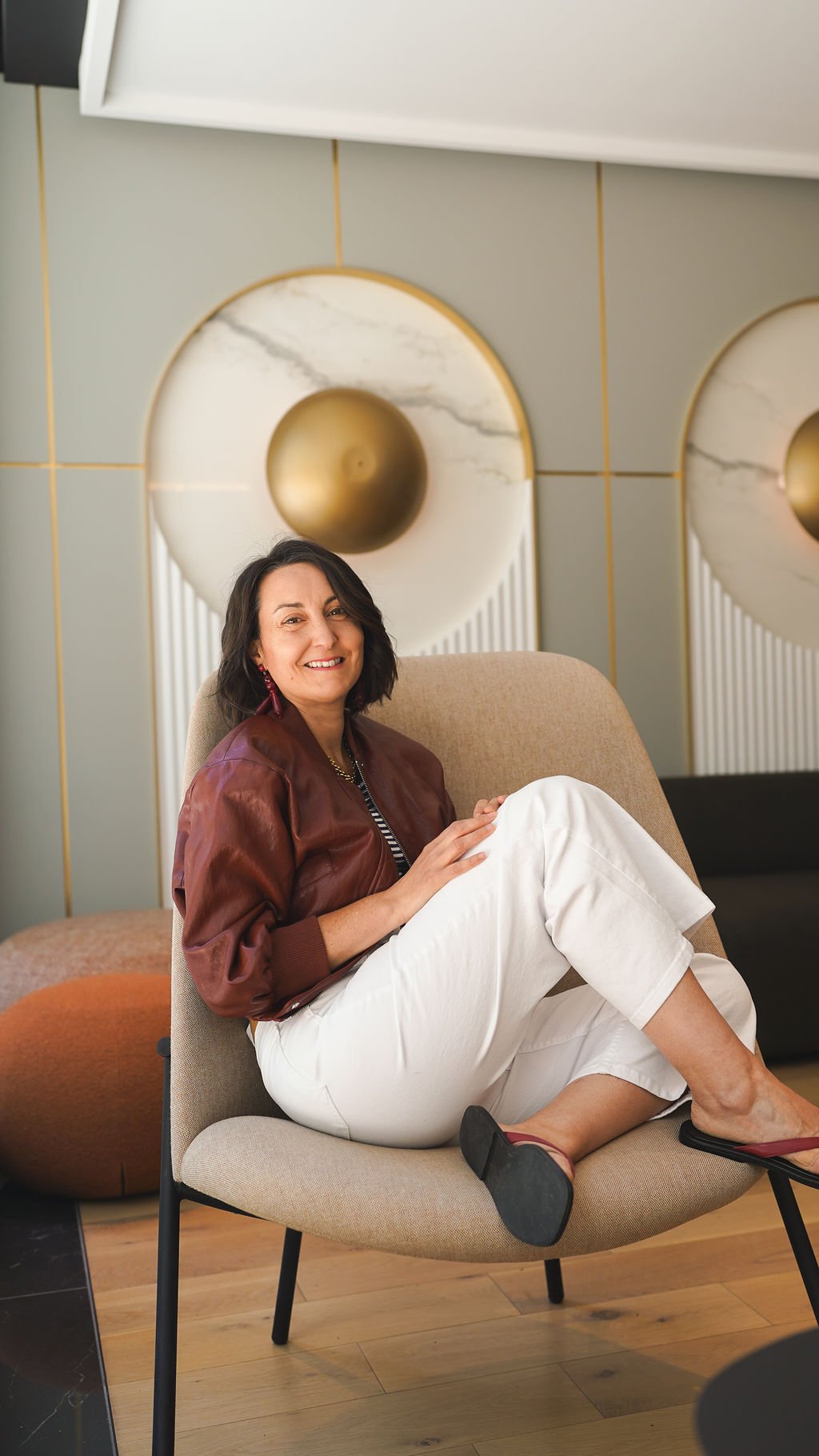 Jaime assise dans un fauteuil design, souriante, pour la section À propos