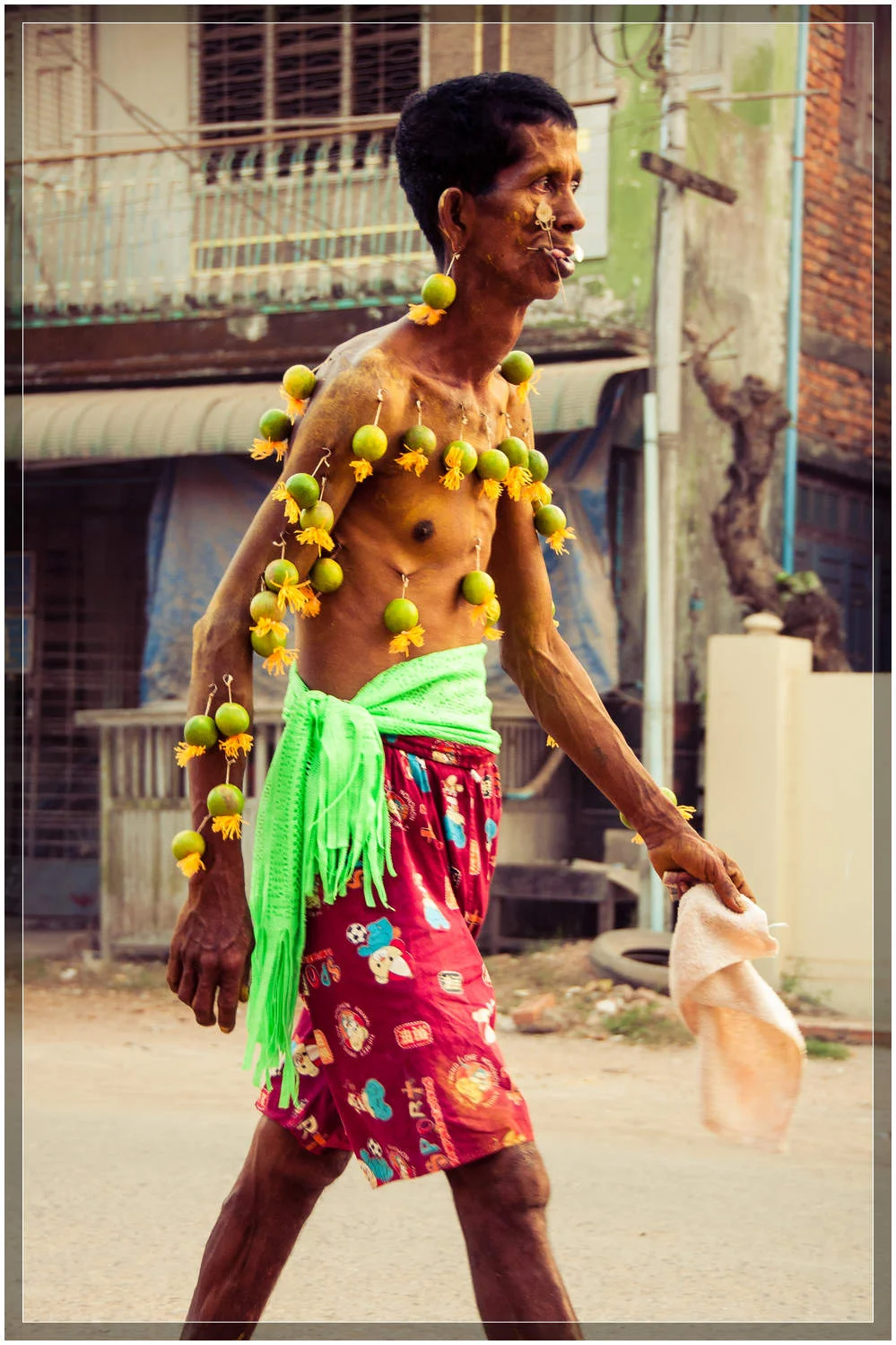 I was told that this man from the neighborhood has few belongings, but has faith that runs deep. His body had over two dozen limes hanging from metal hooks in his skin. © Dustin Main 2013