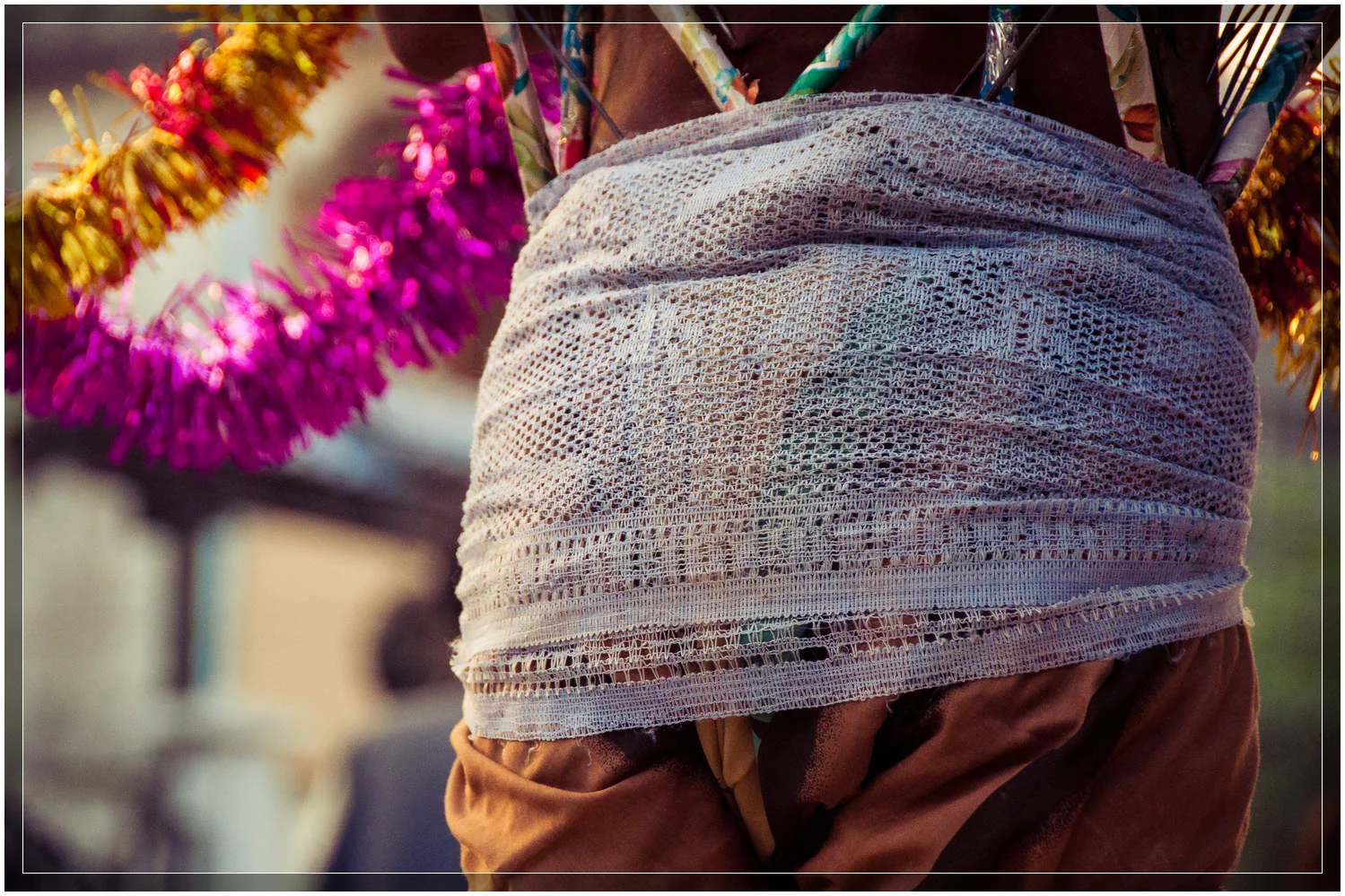A wrap around the lower torso to prevent the movement of the spears while walking. Mawlamyine, Myanmar (Burma). © Dustin Main 2013