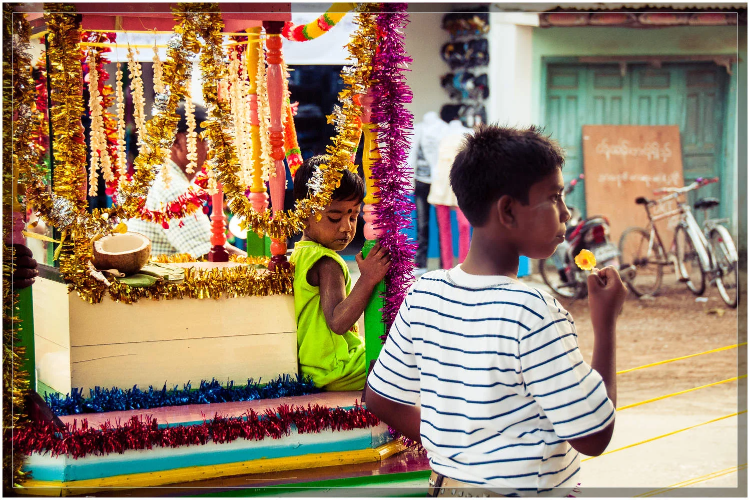 A child rides atop a carriage being pulled by a devotee in this Hindu ceremony. © Dustin Main 2013