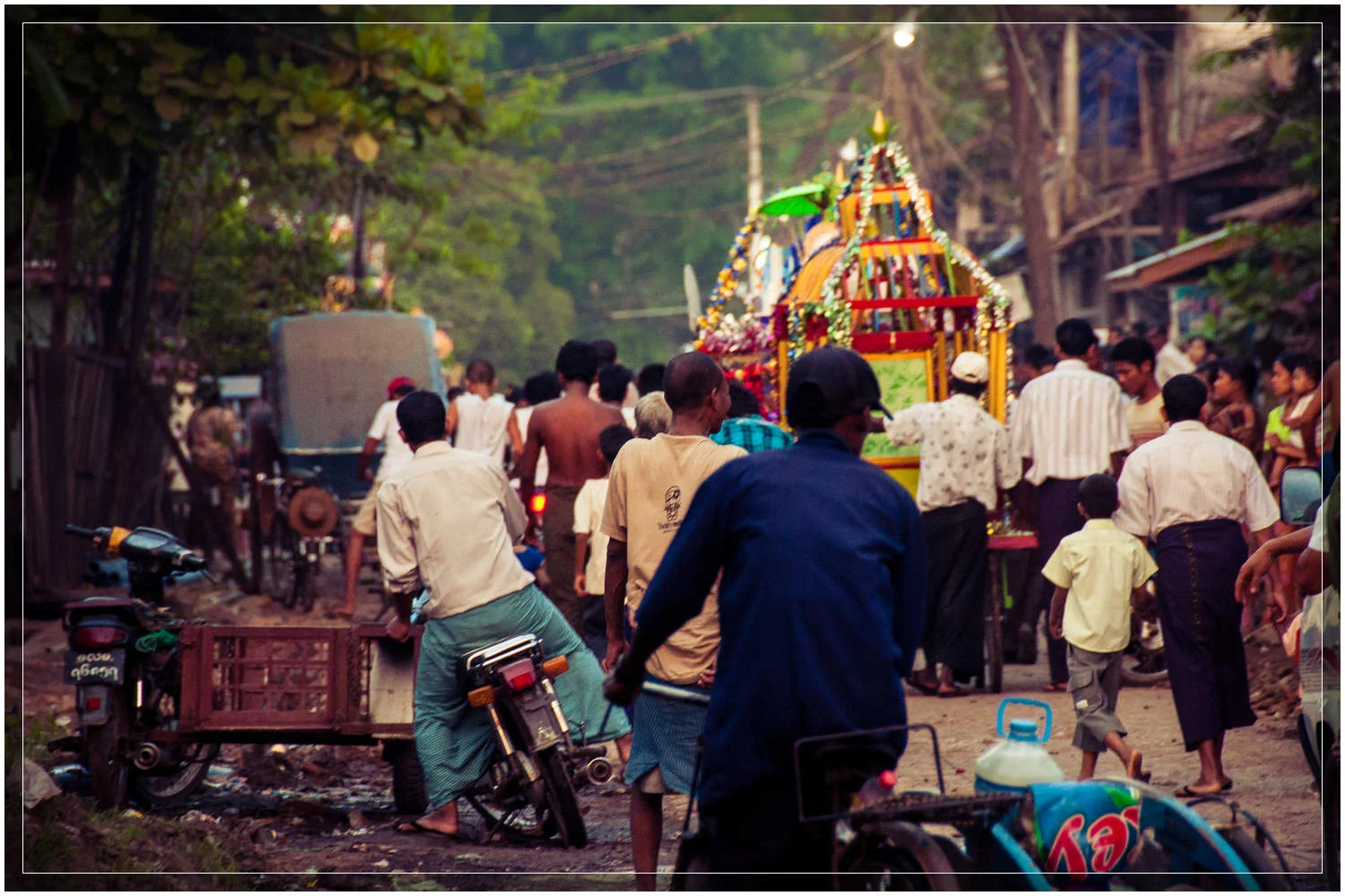 The procession continues down a side street en route to the temple. While comprising mostly of Buddhists, Myanmar (Burma) is home to people practicing many religions including sizable Christian and Hindu populations. © Dustin Main 2013
