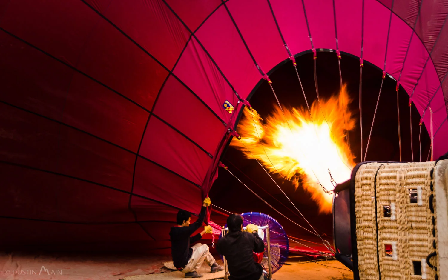 Burners are on full blast as the staff push air into the balloon in Bagan. © Dustin Main 2013