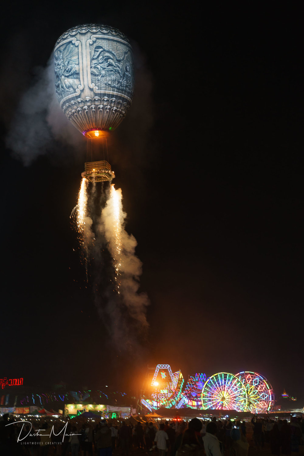  The human-powered ferris wheel and the rest of the festival grounds in the background as a fire balloon rises over the field.  © Dustin Main 2016 