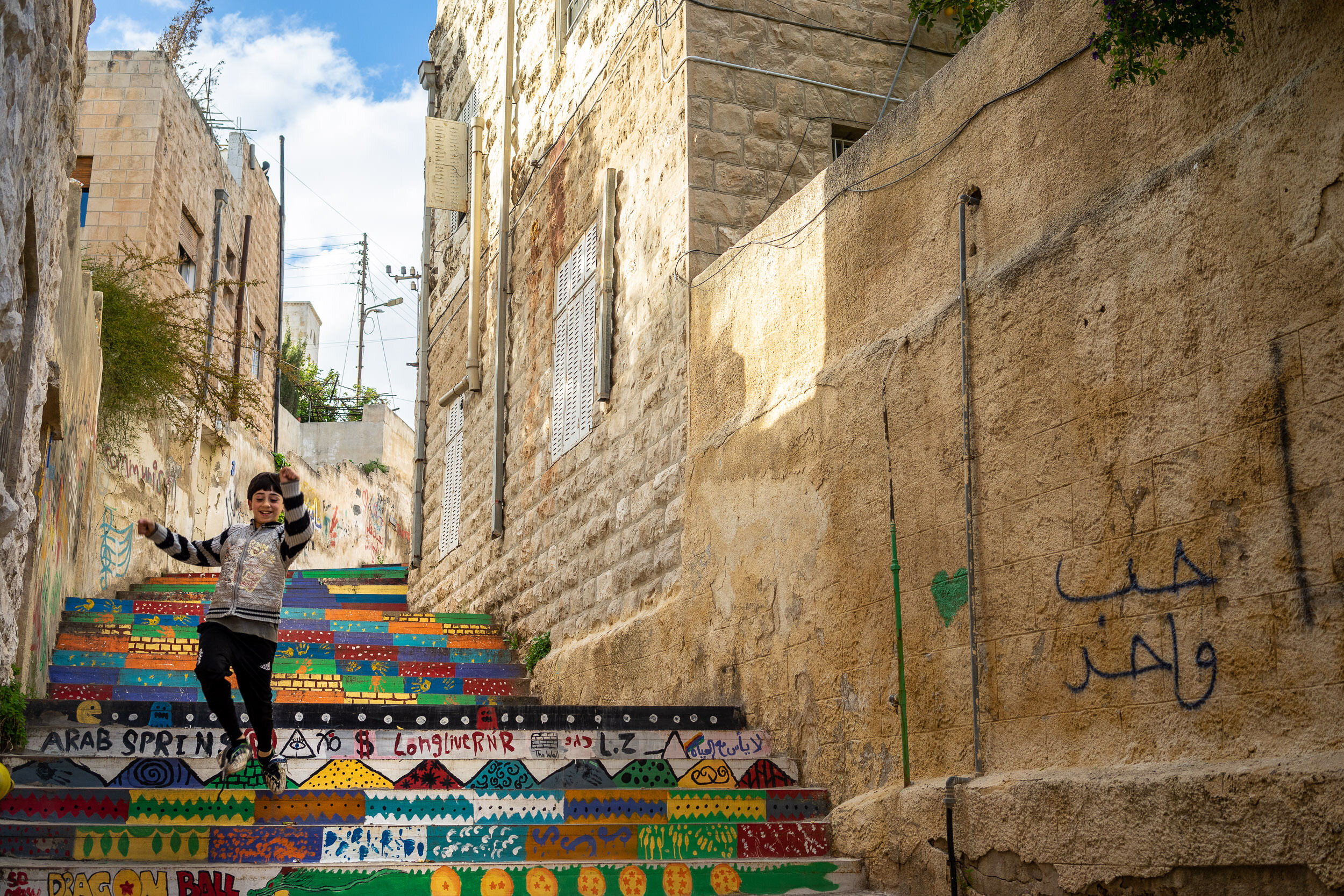 This young guy is having a brilliant time running down colorful steps in Amman