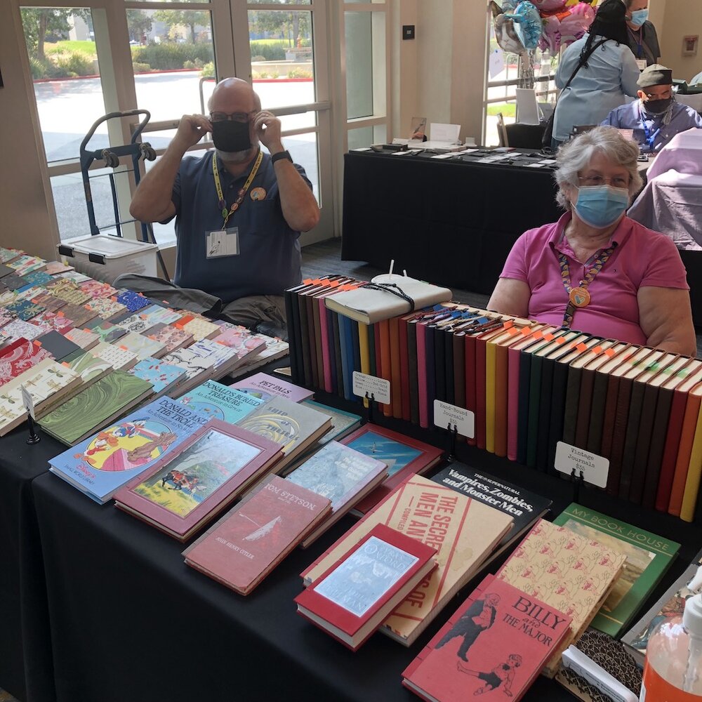 Steve and Diane Curnow and their array of bound notebooks (they use vintage and recycled book covers along with laser-etched wood covers too) and inserts and leather covers.