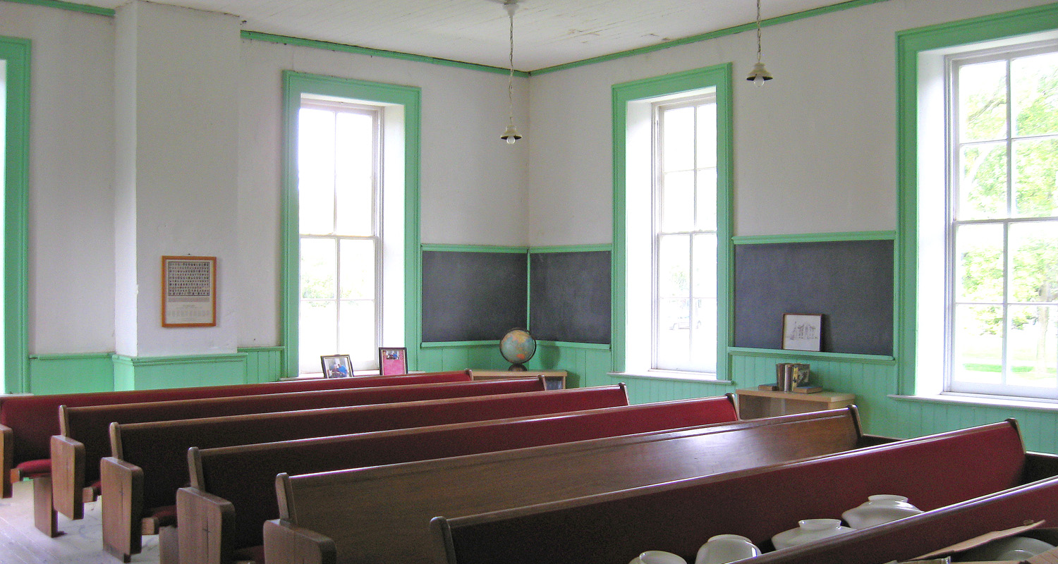  School room inside with pew style seating.&nbsp; Note that the hanging light globes are in the process of being replaced. 