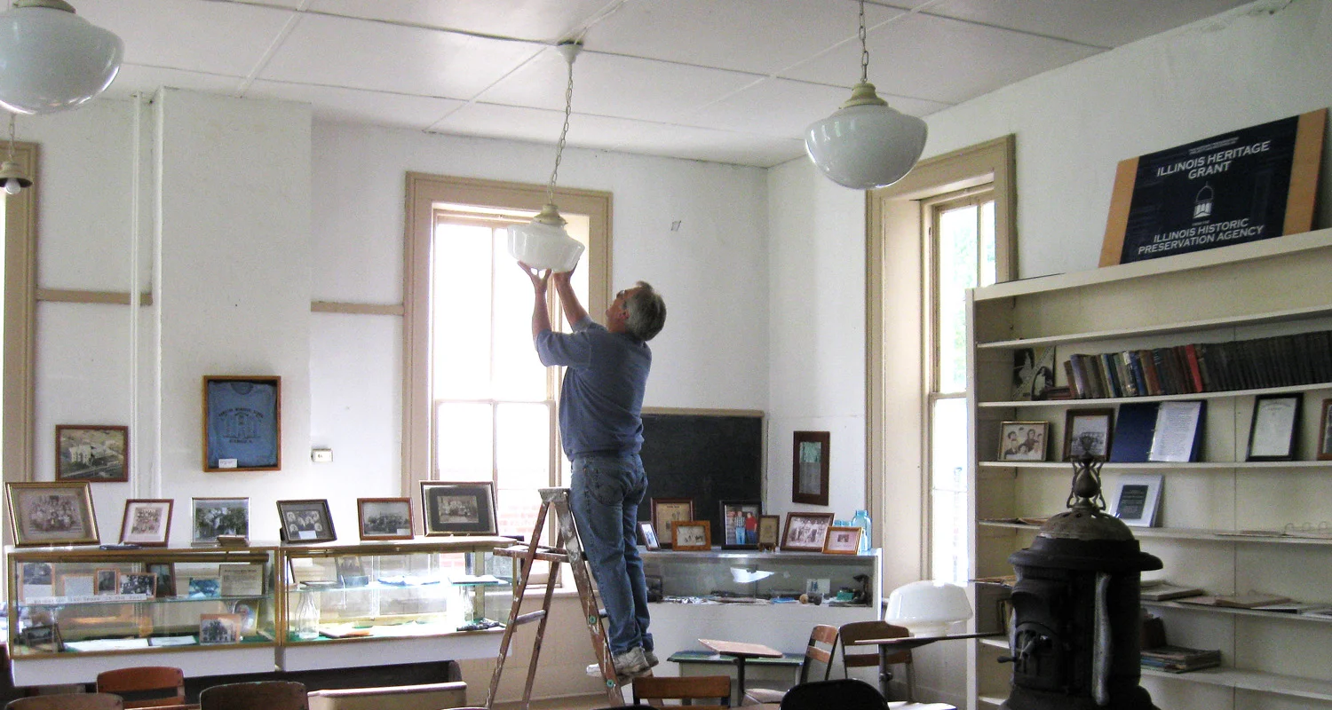 Jim Woolsey, Board member, installing new light globes as many were missing. These were later replaced with globes found to be more similar to the original globes.