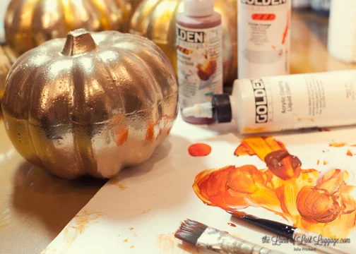 To bring the pumpkins from their $3 state up to a $15 look, I glazed on some Quinacridone Nickel Azo gold paint plus Vat Orange. The Acrylic Glazing Liquid (Golden) allows a long working time so I can lay in some color and then come back in with a clean brush to blend it around. I applied some of the orange mixture in all of the dips.