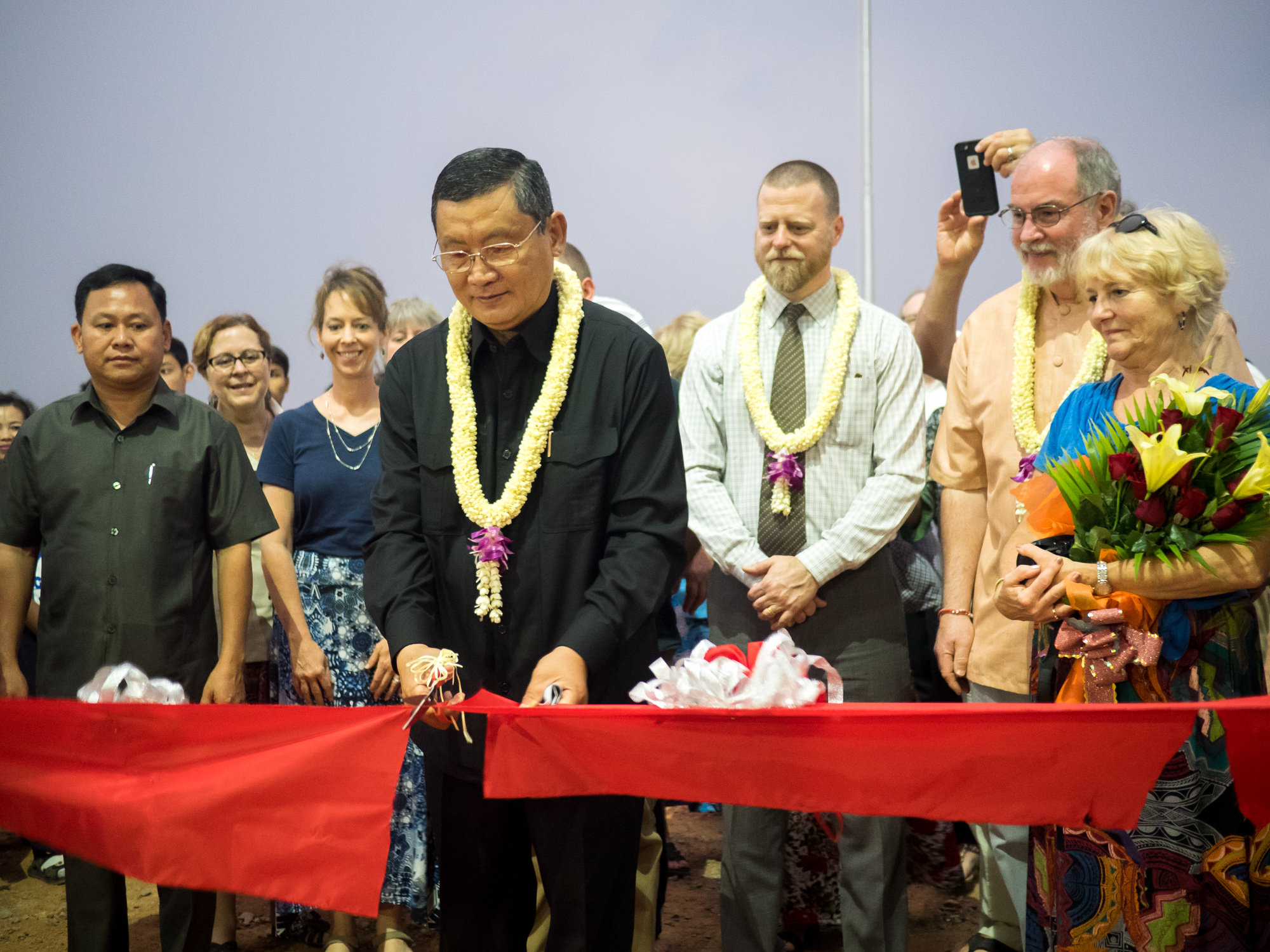 The governor of Battambang Province cuts the ribbon at the Asia's Hope secondary school dedication.