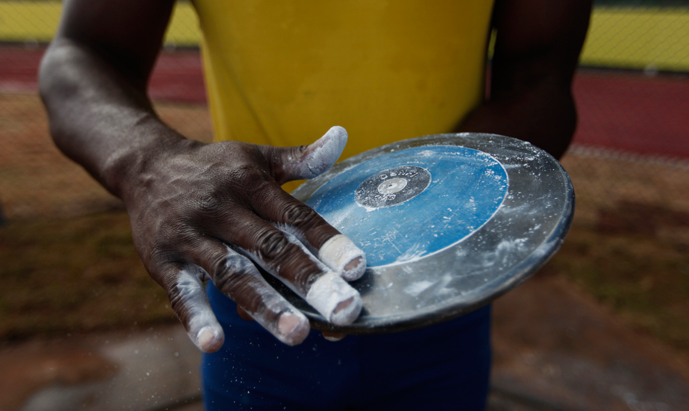  ​  Brazilian Ronald Juliao applies chalk on his discus during a training session at the Athletics Center in Sao Caetano do Sul, near Sao Pauloon in May. Juliao will be taking part at the Olympics. (Nacho Doce/Reuters) 