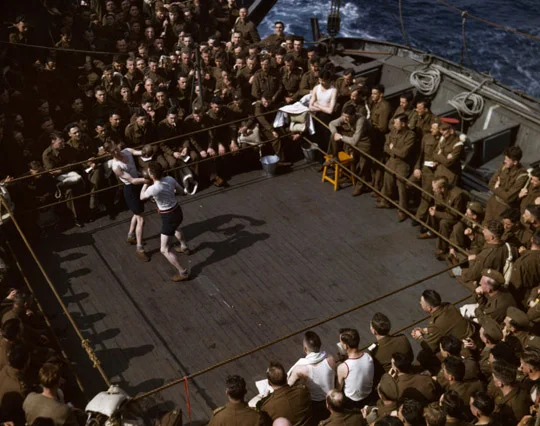 British soldiers watching a wrestling match on a troop ship from England to North Africa, 1943.