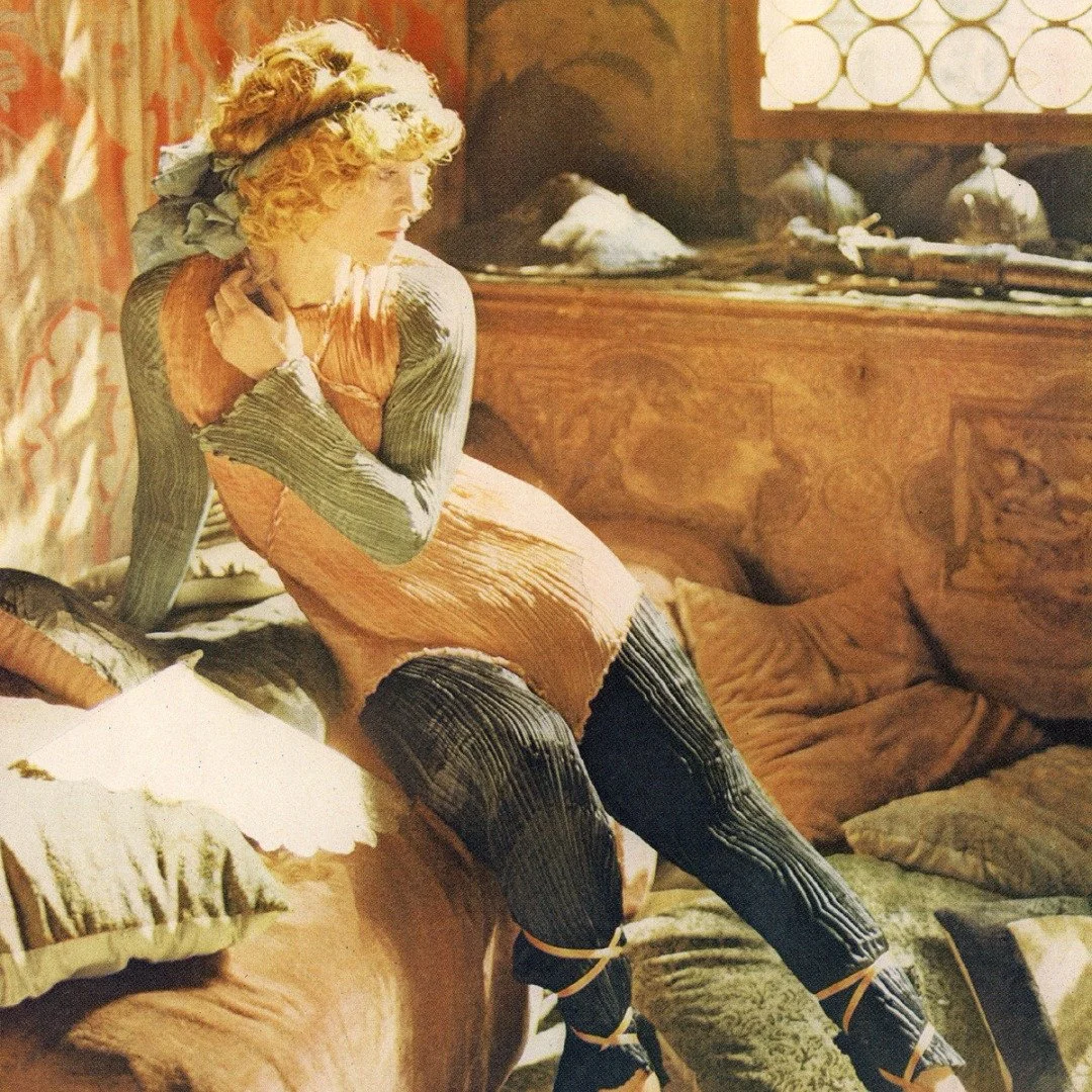 This shot truly looks like a painting. The soft light streaming through the window highlights Julie Christie, who sits gracefully on a daybed surrounded by cushions and pieces of fabric. The beautiful Fortuny curtains in the background add depth and 