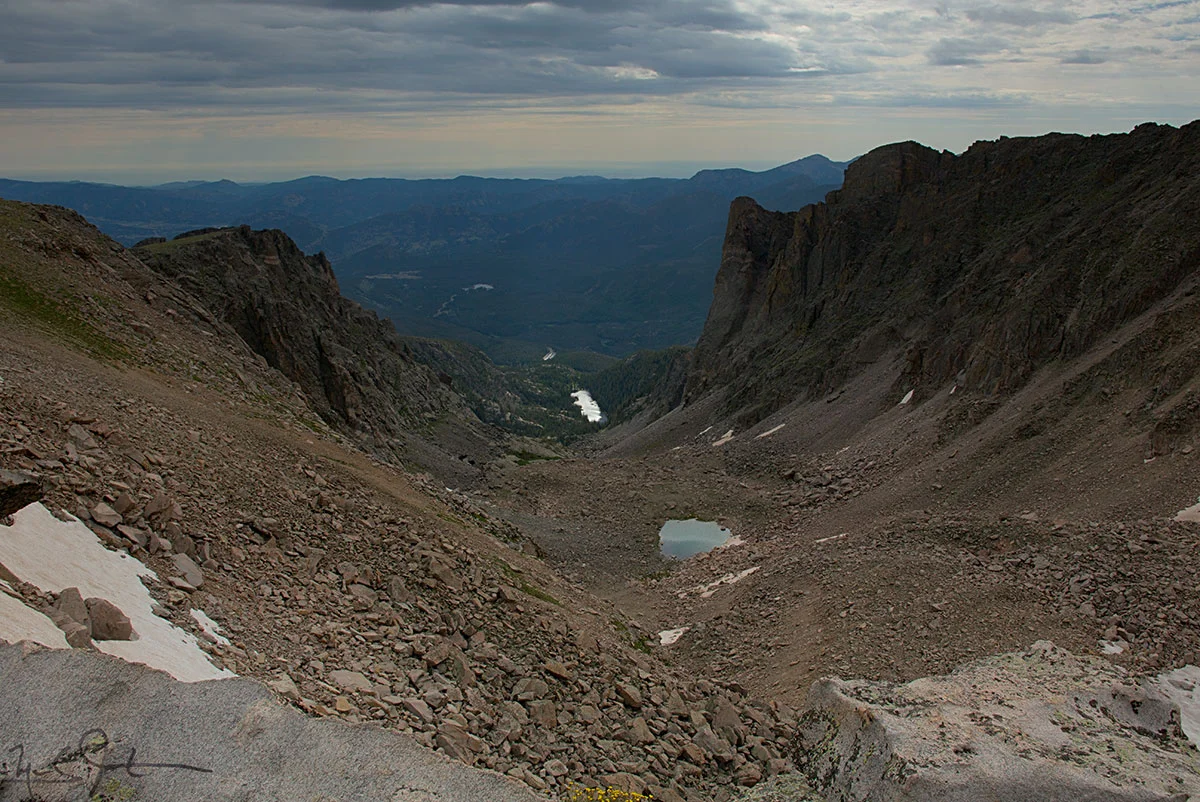 Looking down Tyndall Gorge from just above Tyndall Glacier at around 12,000 ft. The "glacier" is now reduced to a small dirty patch of snow by rising temperatures. In the distance, Pool of Jade, then Dream Lake, and a glimpse of Bear Lake Road below.