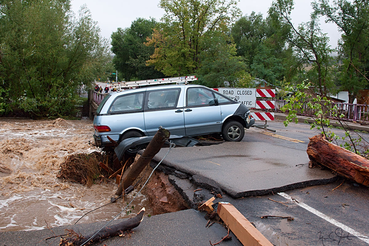 A vehicle lays stranded on the 5th Ave. bridge as the south fork of the St. Vrain River rushes just below street level. Further up the S. St. Vrain Canyon, Rt. 7 was washed out in multiple places, blocking access into the mountains and Estes Park.