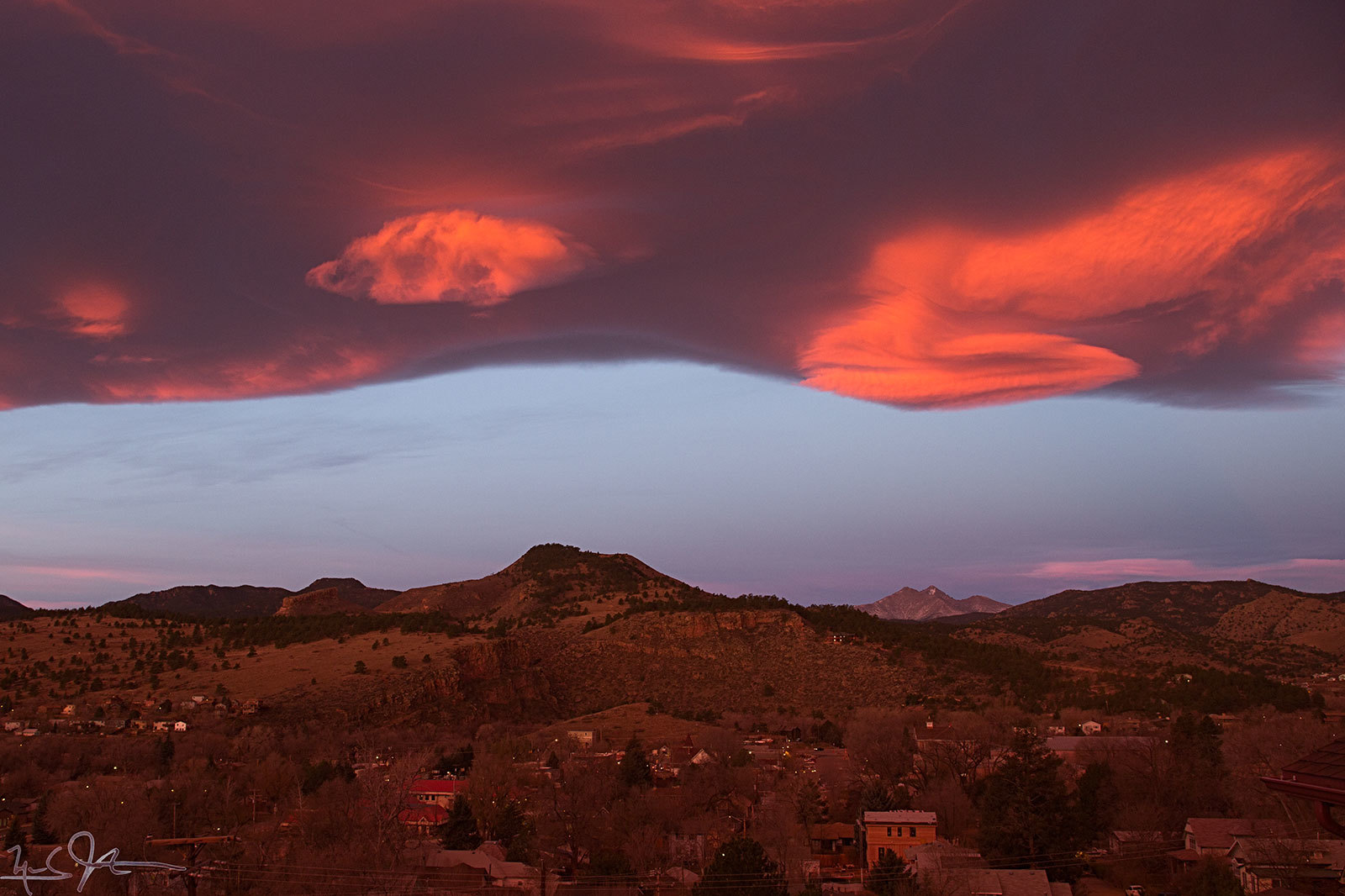 A cloud bank lies just east of the Continental Divide, with some lenticular shapes protruding.