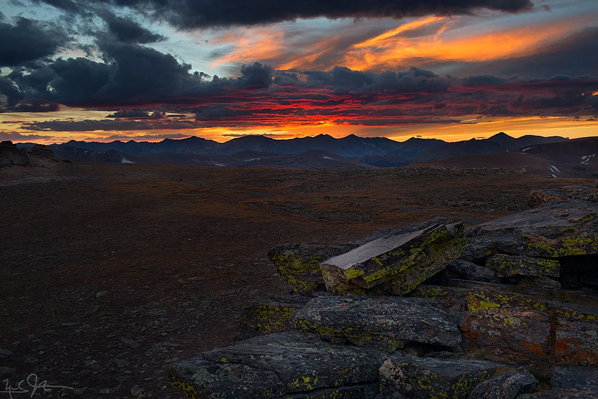 The setting sun reflects light off the underside of the clouds. Gore range in the distance.