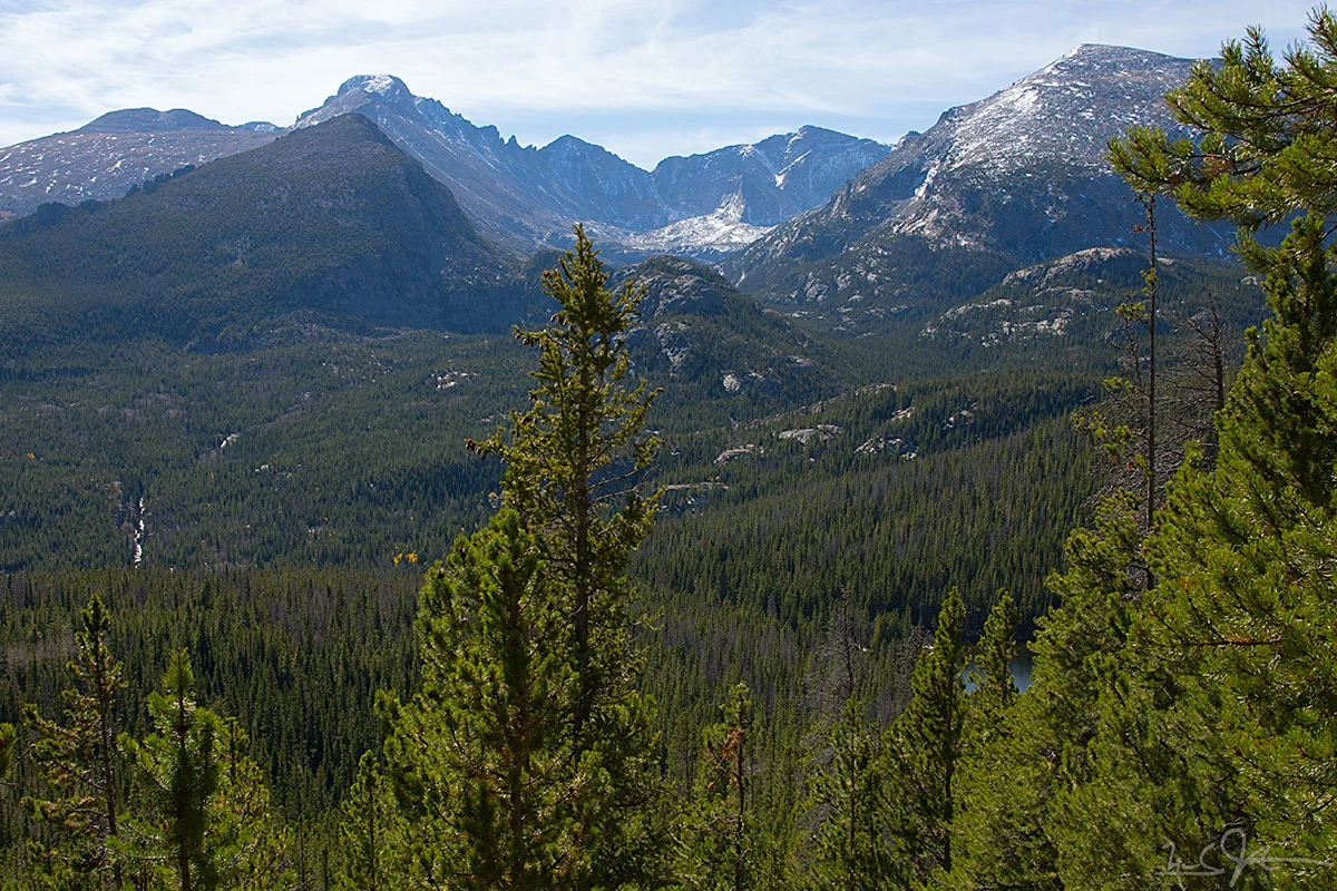 Coming back down the trail, a view southward towards Glacier Gorge, with the Glacier Knobs in the mid-ground and Long's Peak, Keyboard of the Winds, Pagoda Mountain, and Chiefs Head Peak on the horizon. The east end of Bear Lake is visible in the foreground at right.